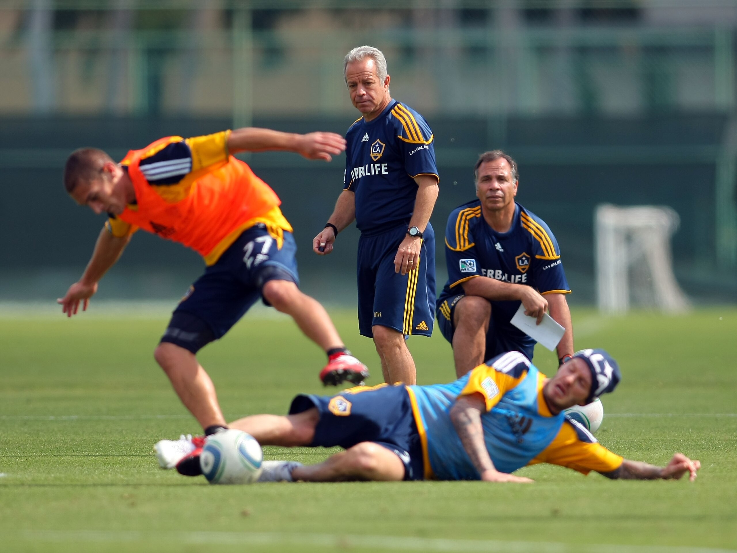CARSON, CA - FEBRUARY 24:  Assistant Coach Dave Sarachan (L) and Head Coach Bruce Arena (R) watch as David Beckham #23 of the Los Angeles Galaxy tackles teammate Bryan Jordan #27 during training at The Home Depot Center on February 24, 2011 in Carson, Cal