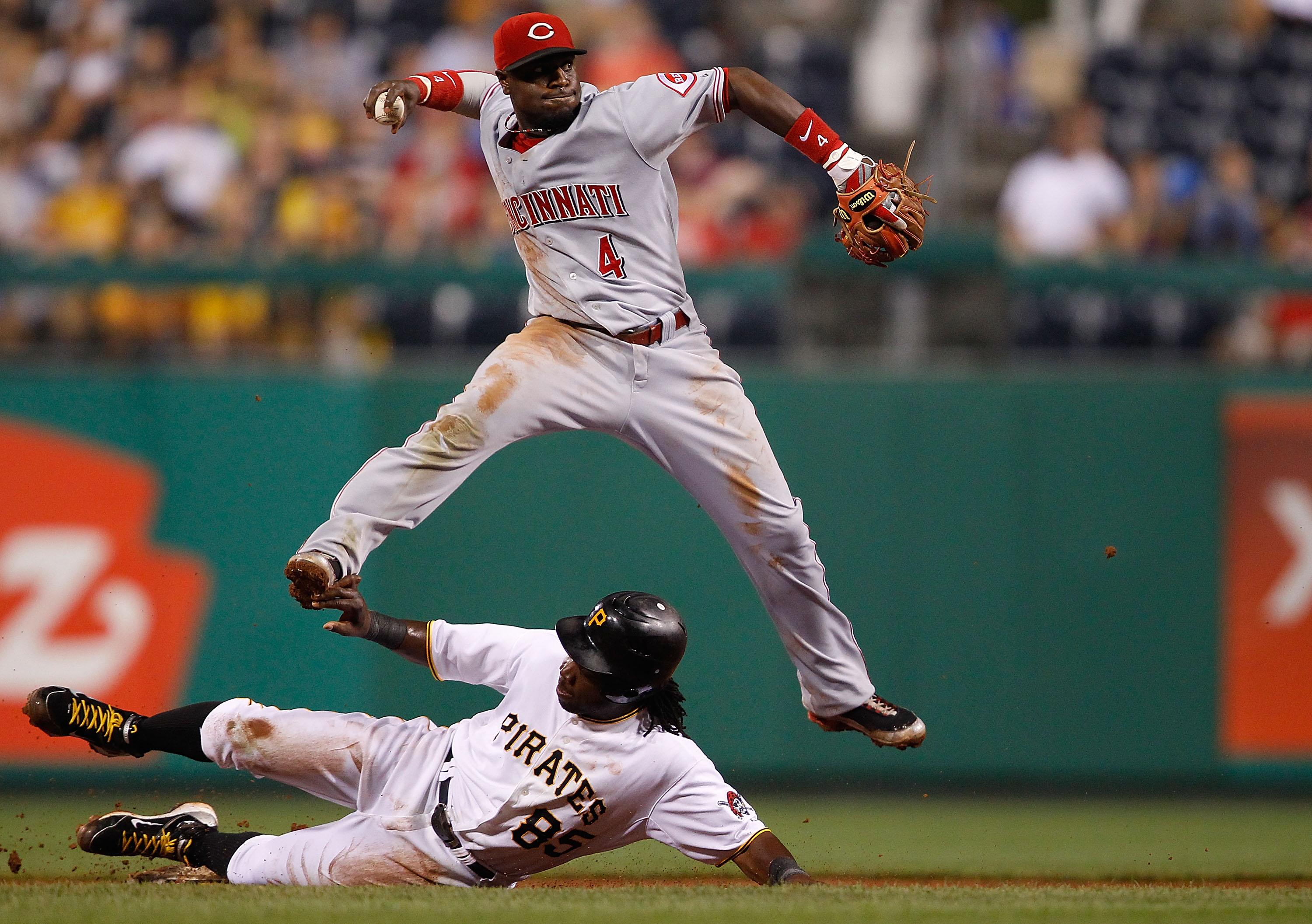 PITTSBURGH - AUGUST 03:  Brandon Phillips #4 of the Cincinnati Reds attempts to turn the double play over Lastings Milledge #85 of the Pittsburgh Pirates during the game on August 3, 2010 at PNC Park in Pittsburgh, Pennsylvania.  (Photo by Jared Wickerham