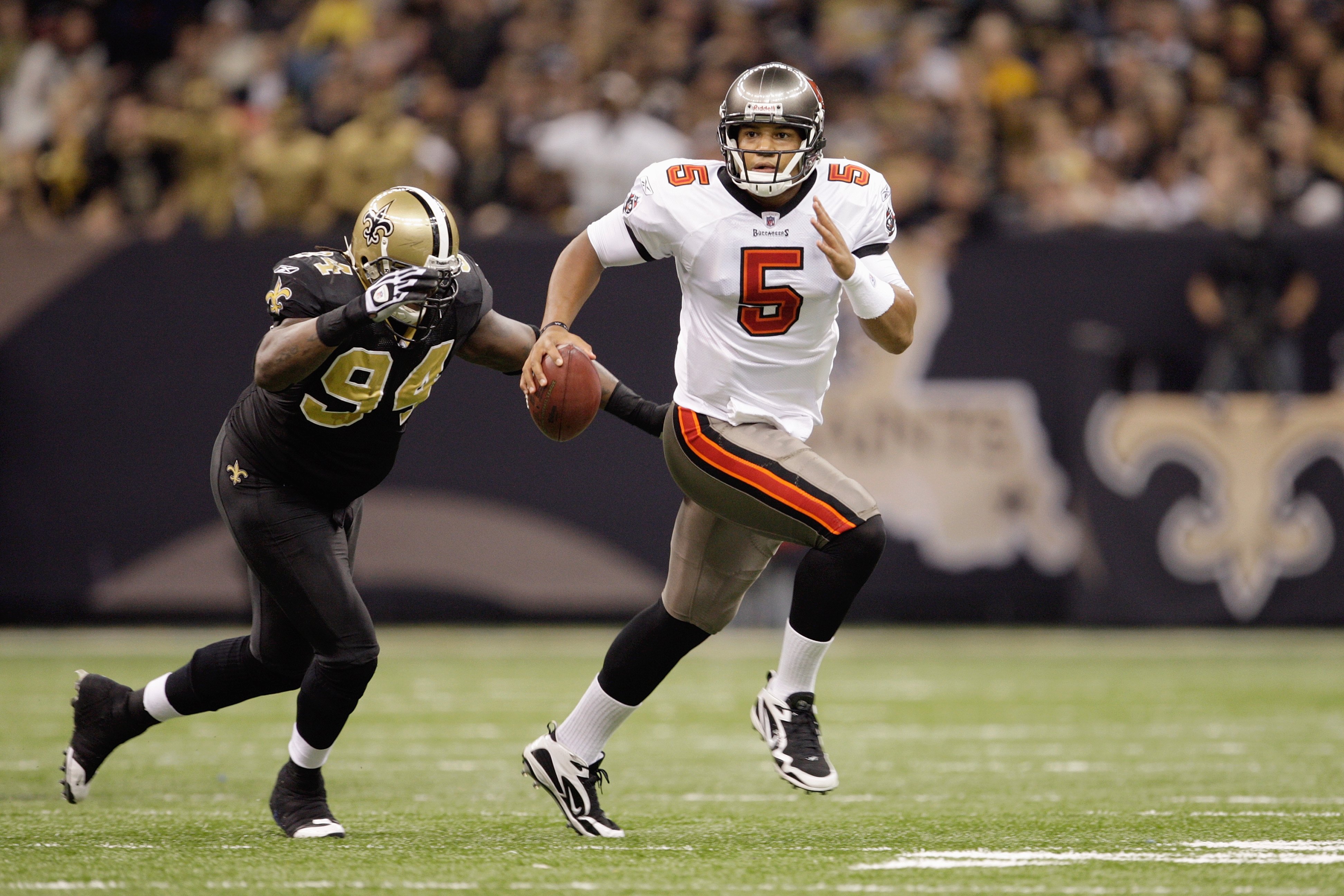 NEW ORLEANS - DECEMBER 27:  Head coach Josh Freeman #5 of the Tampa Bay Buccaneers runs with the ball against Charles Grant #94 of the New Orleans Saints at the Louisiana Superdome on December 27, 2009 in New Orleans, Louisiana. (Photo by Jamie Squire/Get
