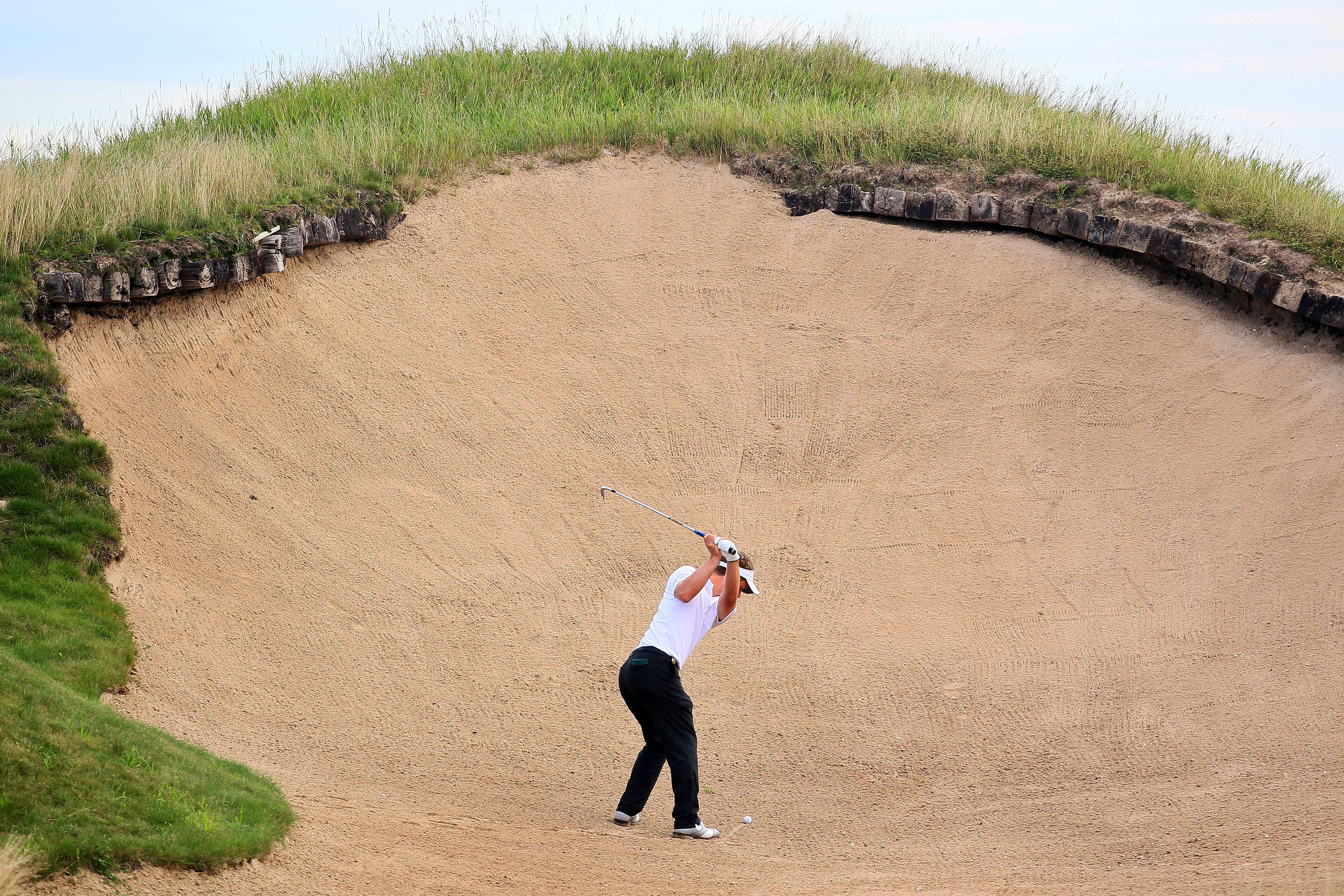 KOHLER, WI - AUGUST 14:  Luke Donald of England plays a bunker shot on the 11th hole during the continuation of the second round of the 92nd PGA Championship on the Straits Course at Whistling Straits on August 14, 2010 in Kohler, Wisconsin.  (Photo by An