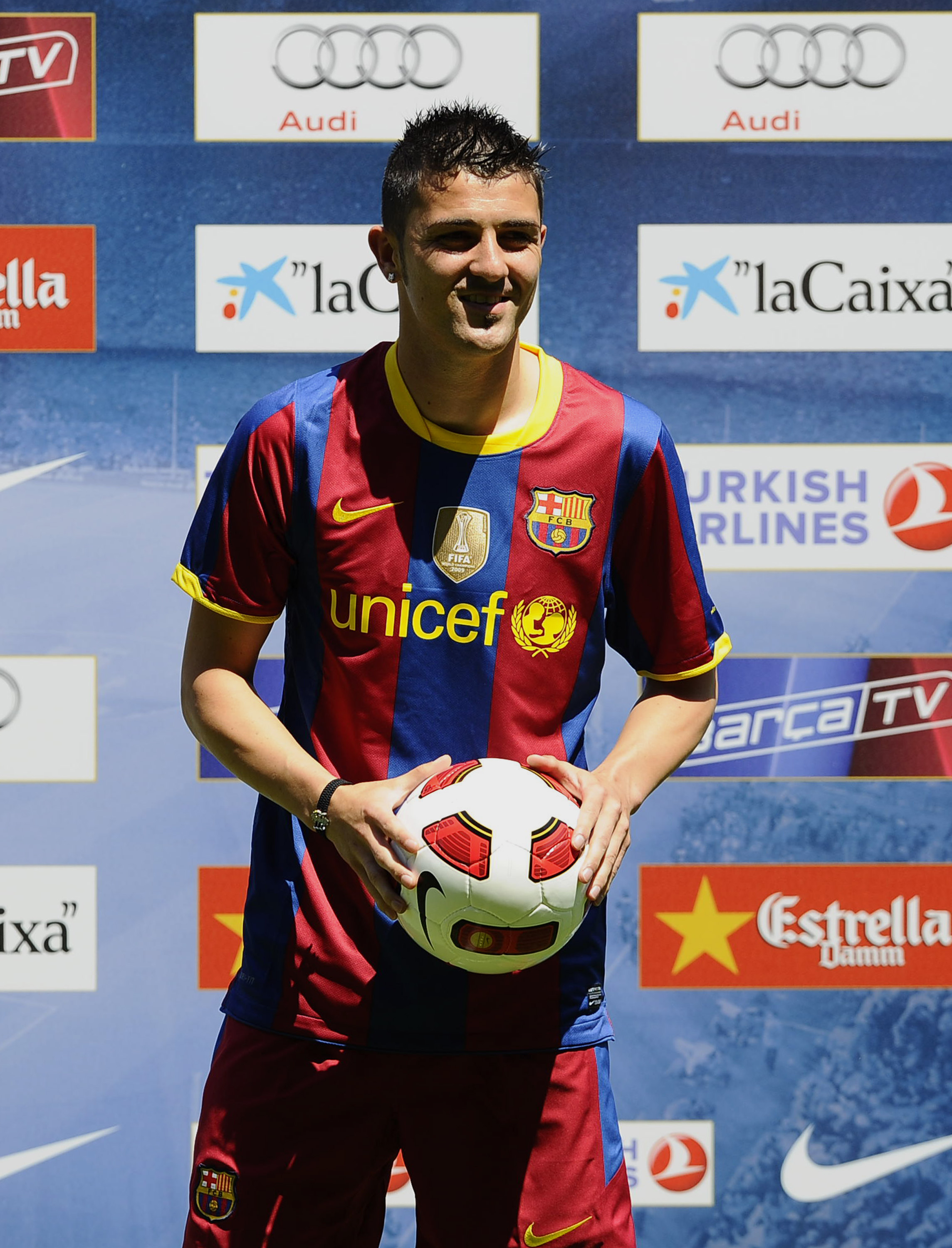 BARCELONA, SPAIN - MAY 21:  Barcelona's new signing David Villa holds the ball as he poses for the cameras during his presentation at the Camp Nou stadium on May 21, 2010 in Barcelona, Spain.  (Photo by Siu Pong Wu Lau/Getty Images)