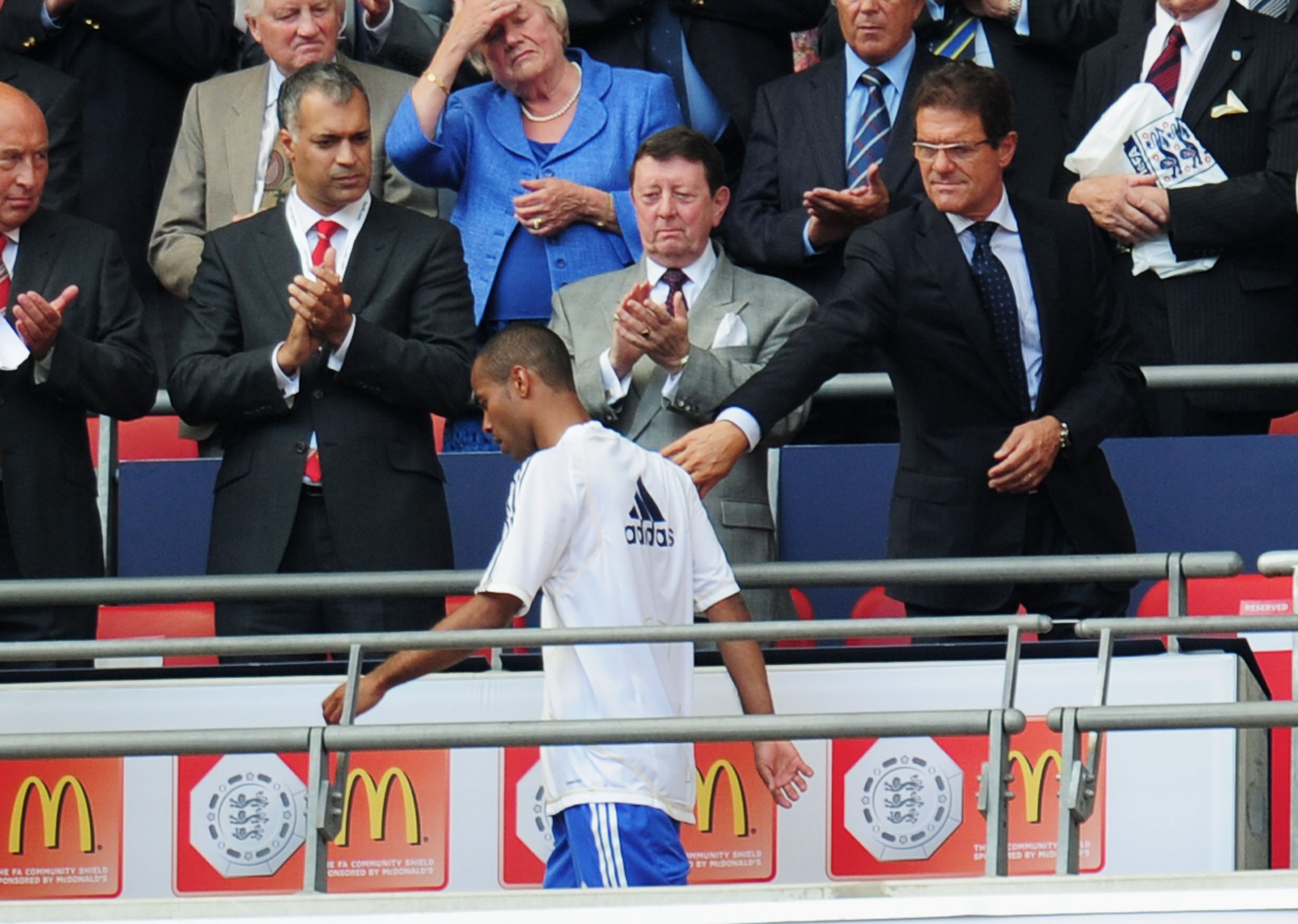 LONDON, ENGLAND - AUGUST 08:  Ashley Cole of Chelsea walks past England manager Fabio Capello as he collects his medal after defeat in the FA Community Shield match between Chelsea and Manchester United at Wembley Stadium on August 8, 2010 in London, Engl