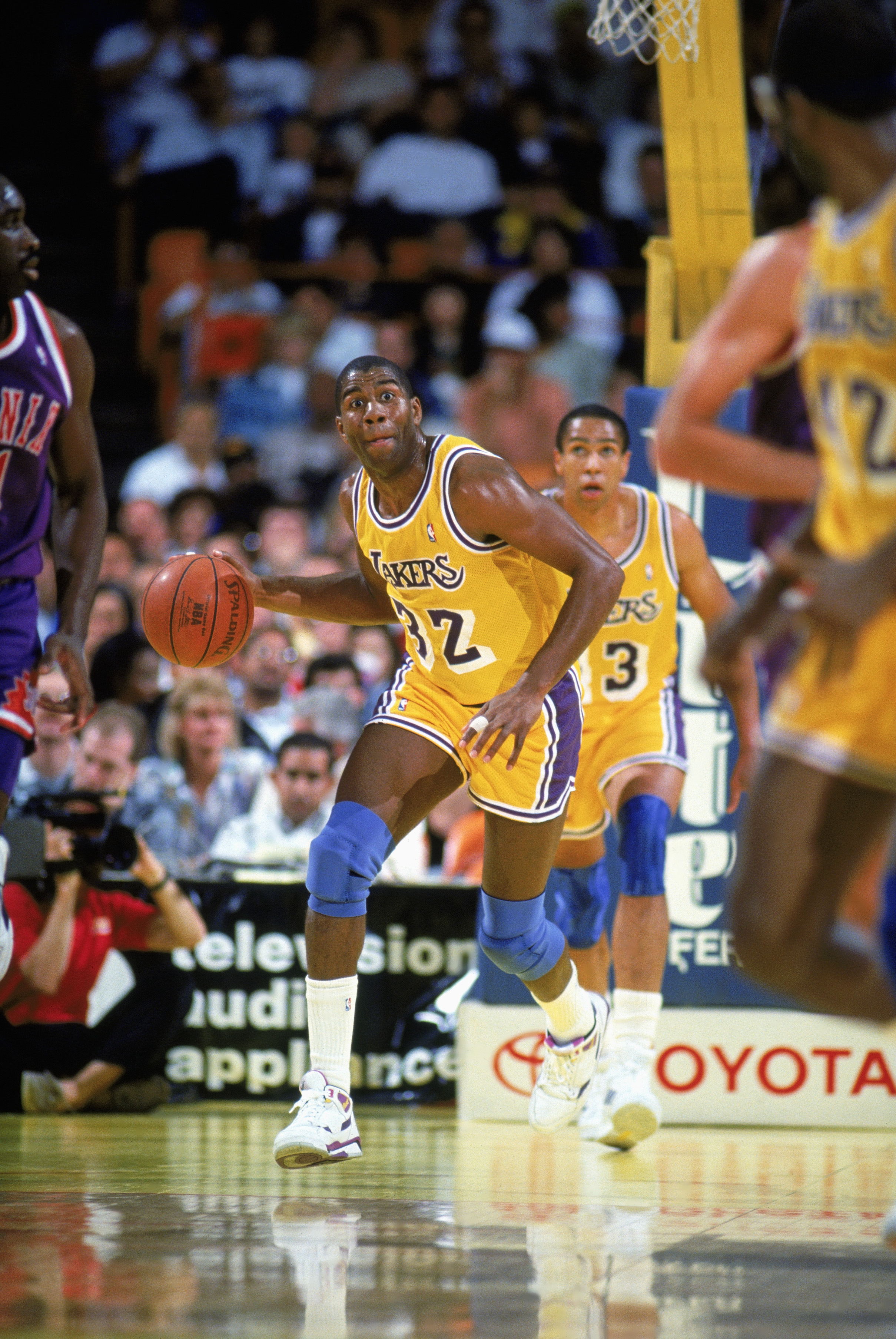 Magic Johnson of the Los Angeles Lakers dribbles against Michael