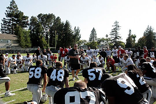 Head coach Tom Cable addresses the team at the end of practice.