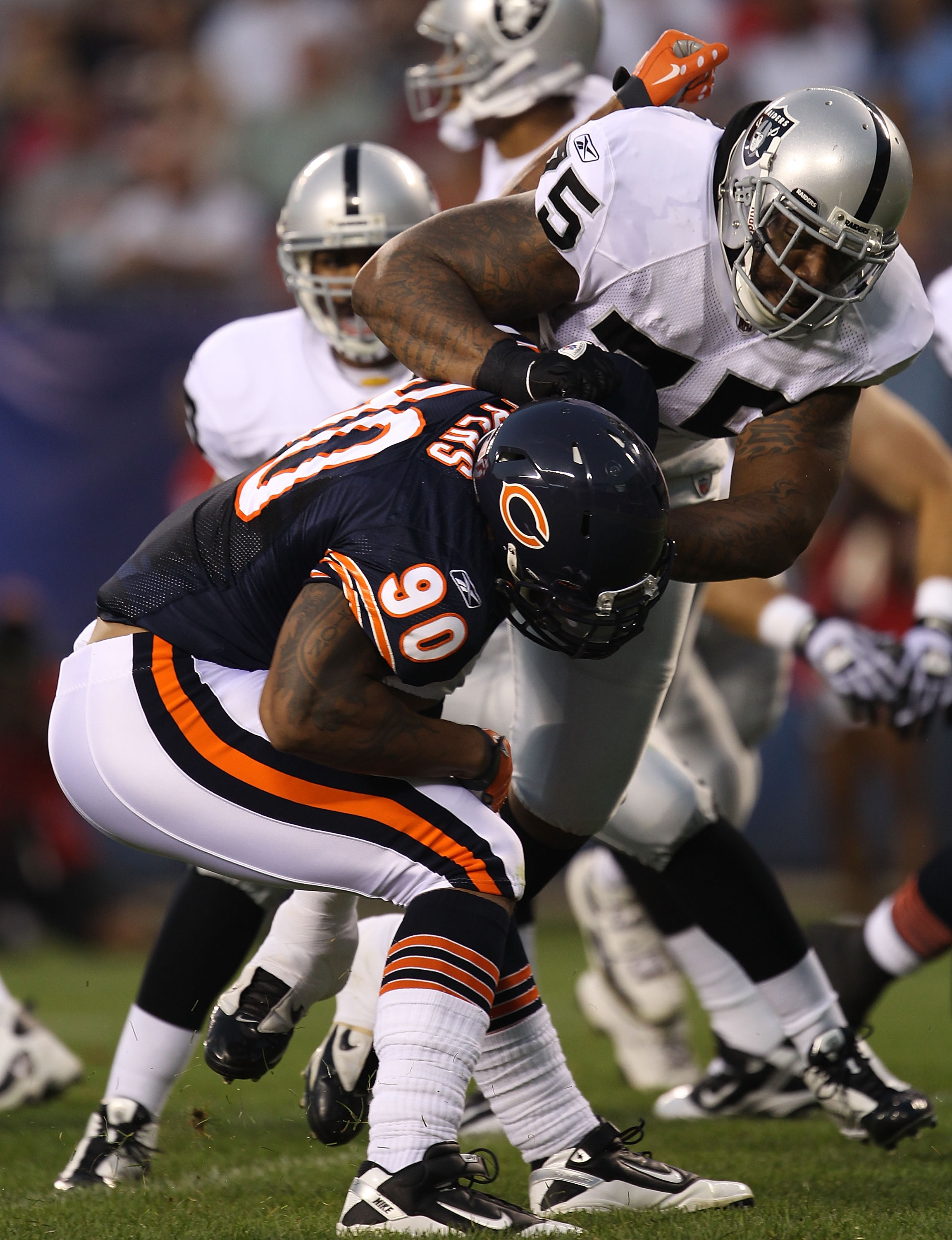 CHICAGO - AUGUST 21: Mario Henderson #75 of the Oakland Raiders blocks Julius Peppers #90 of the Chicago Bears during a preseason game at Soldier Field on August 21, 2010 in Chicago, Illinois. (Photo by Jonathan Daniel/Getty Images)