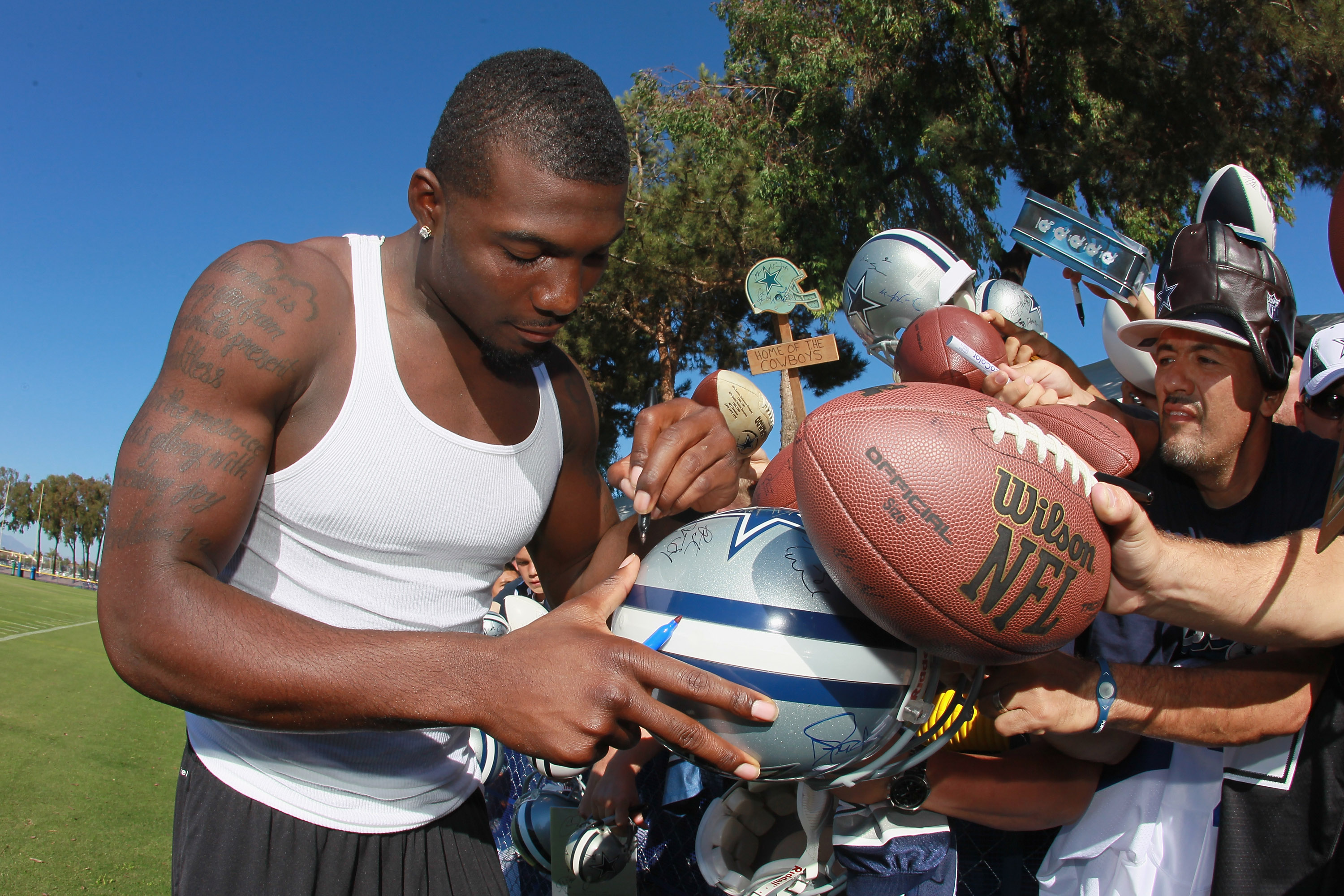 OXNARD, CA - AUGUST 14:  Wide receiver Dez Bryant #88 signs autographs for fans during Dallas Cowboys Training Camp at the Marriott Residence Inn Oxnard River Ridge on August 14, 2010 in Oxnard, California.  (Photo by Jeff Gross/Getty Images)