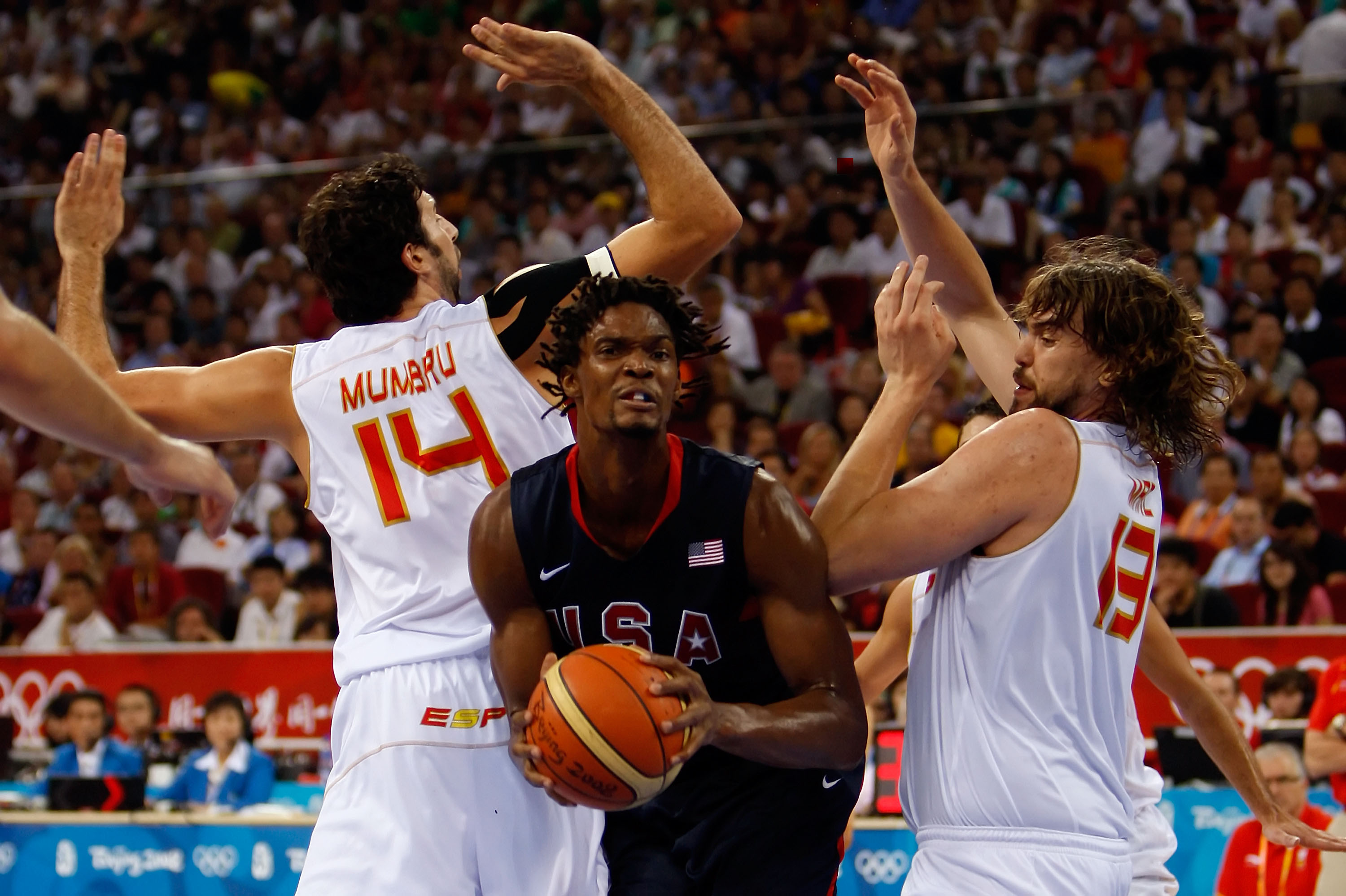 BEIJING - AUGUST 24:  Chris Bosh #12 of the United States moves against the defense of Alex Mumbru #14 and Marc Gasol #13 of Spain in the gold medal game during Day 16 of the Beijing 2008 Olympic Games at the Beijing Olympic Basketball Gymnasium on August