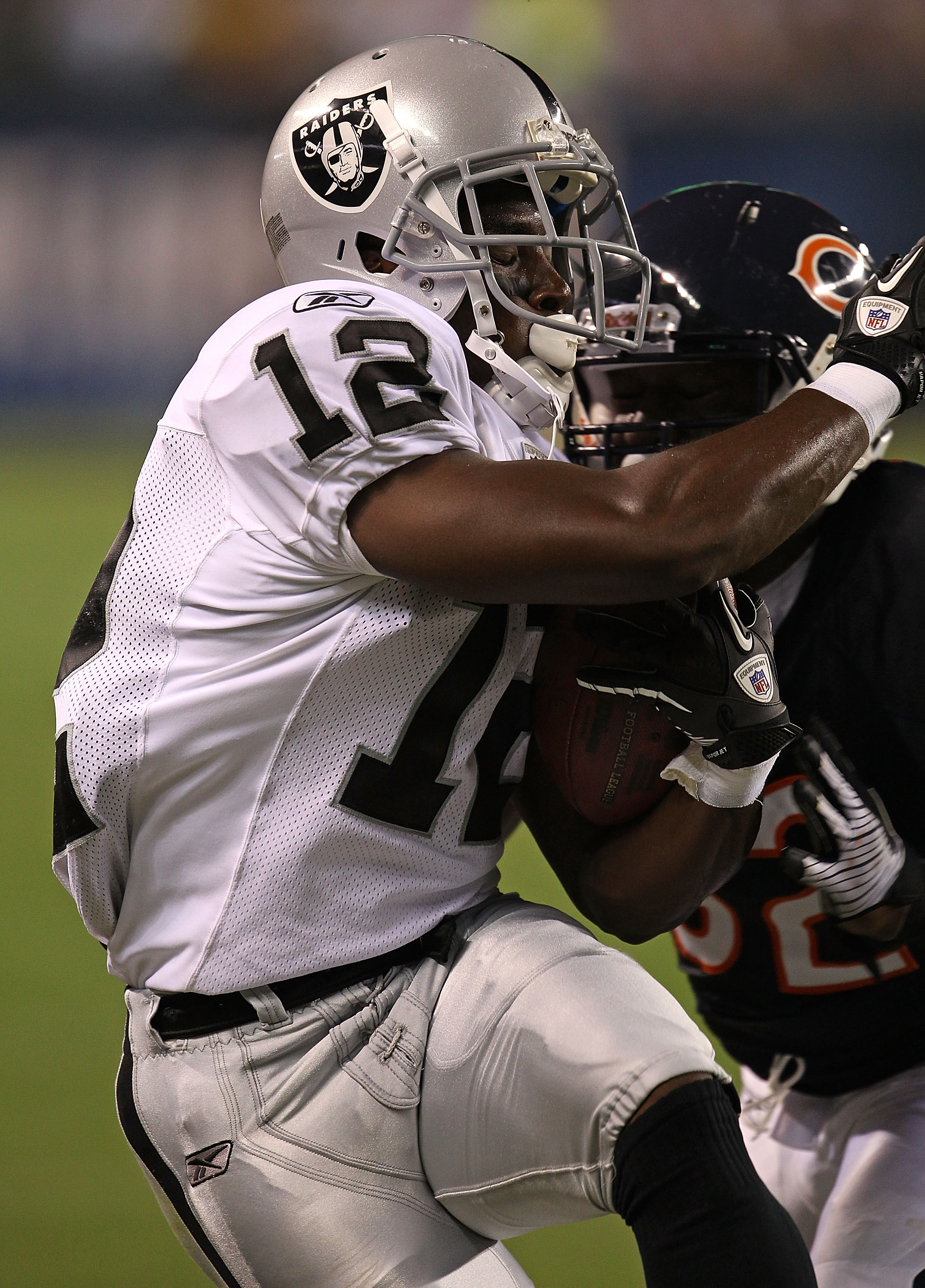 CHICAGO - AUGUST 21: Jacoby Ford #12 of the Oakland Raiders is hit by Kevin Malast #52 of the Chicago Bears during a preseason game at Soldier Field on August 21, 2010 in Chicago, Illinois. The Raiders defeated the Bears 32-17. (Photo by Jonathan Daniel/G