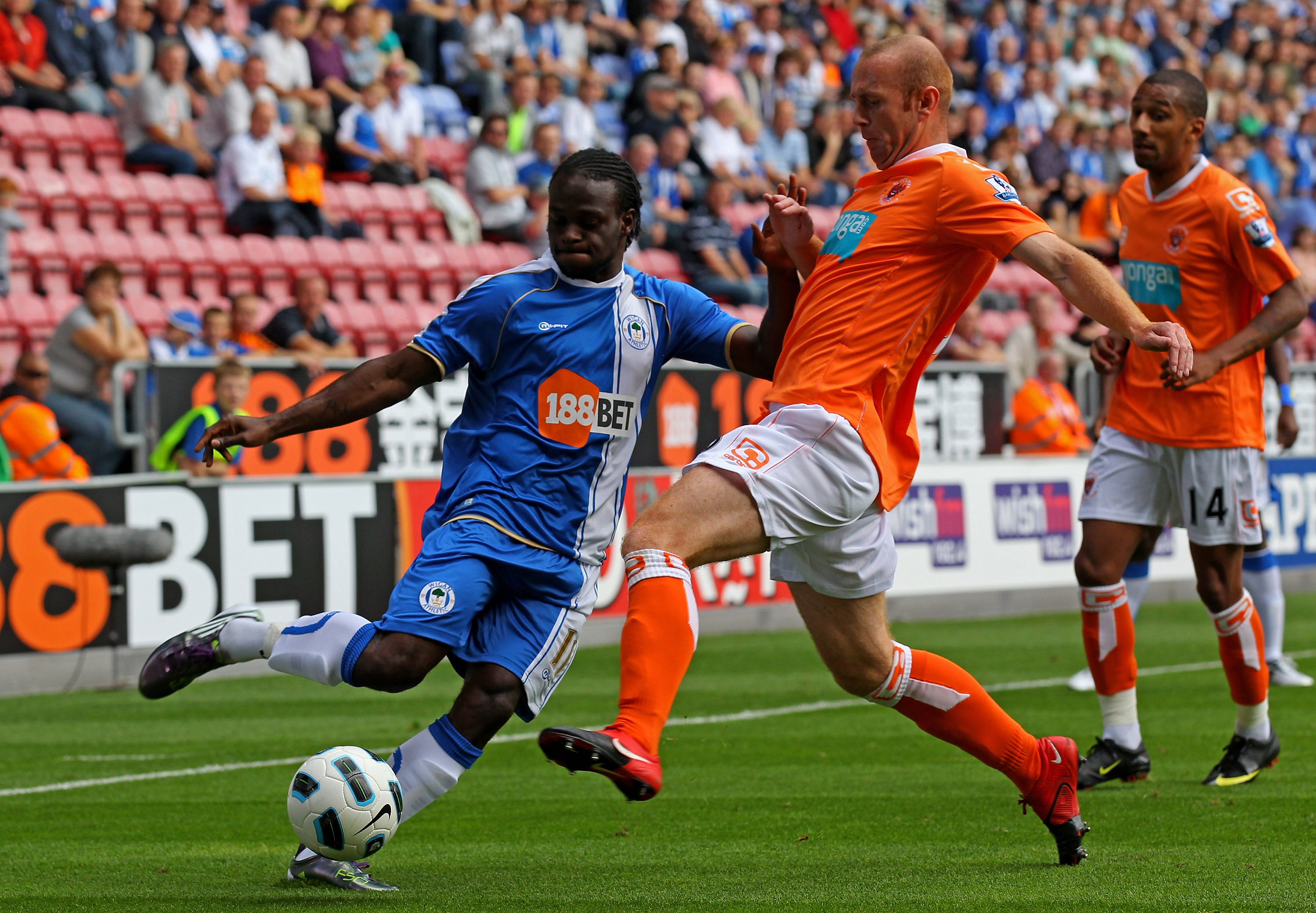 WIGAN, ENGLAND - AUGUST 14: Victor Moses of Wigan Athletic is challenged by Stephen Crainey of Blackpool during the Barclays Premier League match between Wigan Athletic and Blackpool at the DW Stadium on August 14, 2010 in Wigan, England. (Photo by Alex