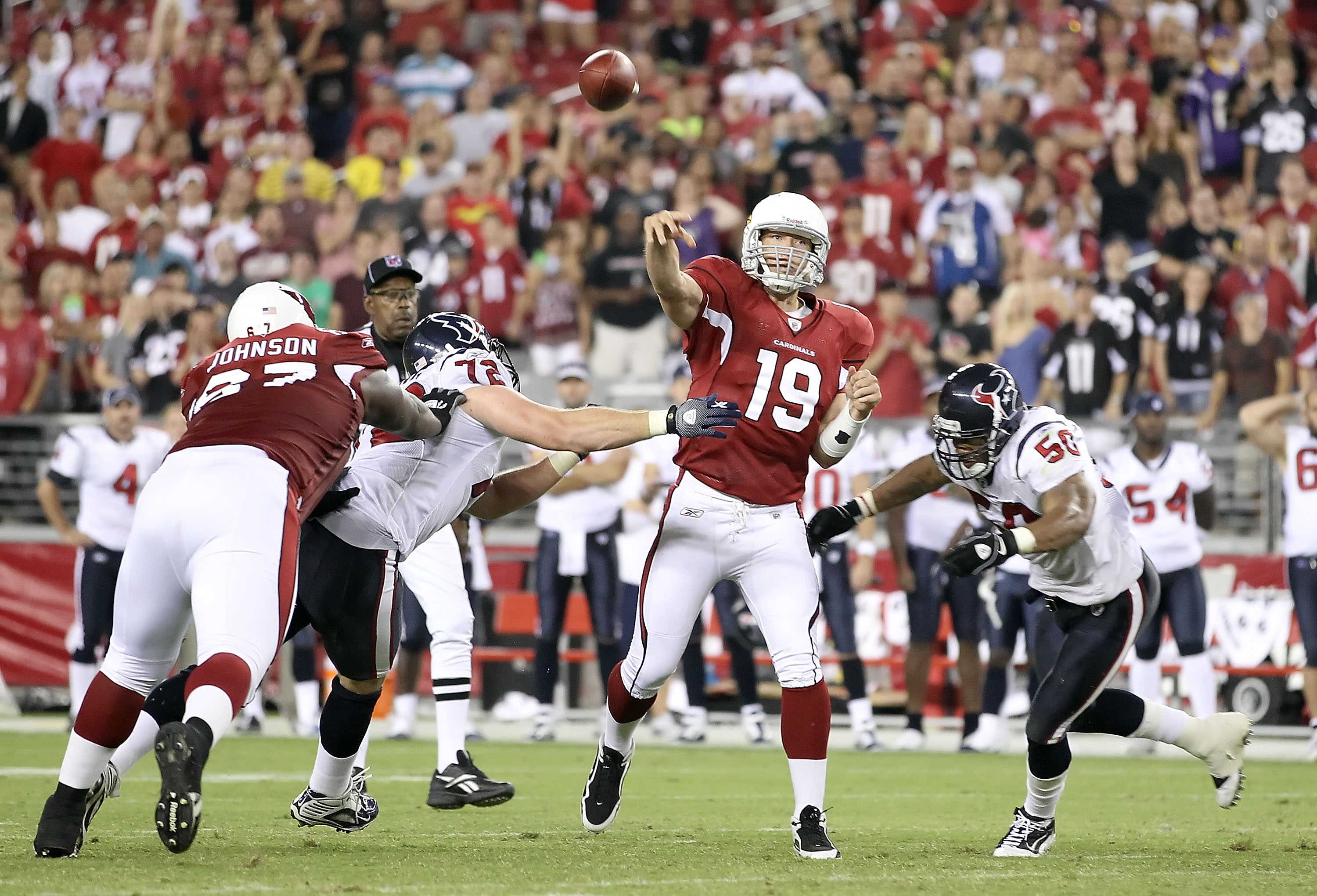 GLENDALE, AZ - AUGUST 14:  Quarterback John Skelton #19 of the Arizona Cardinals throws a pass under pressure from Shelley Smith #72 and Darnell Bing #50 of the Houston Texans during preseason NFL game at the University of Phoenix Stadium on August 14, 20