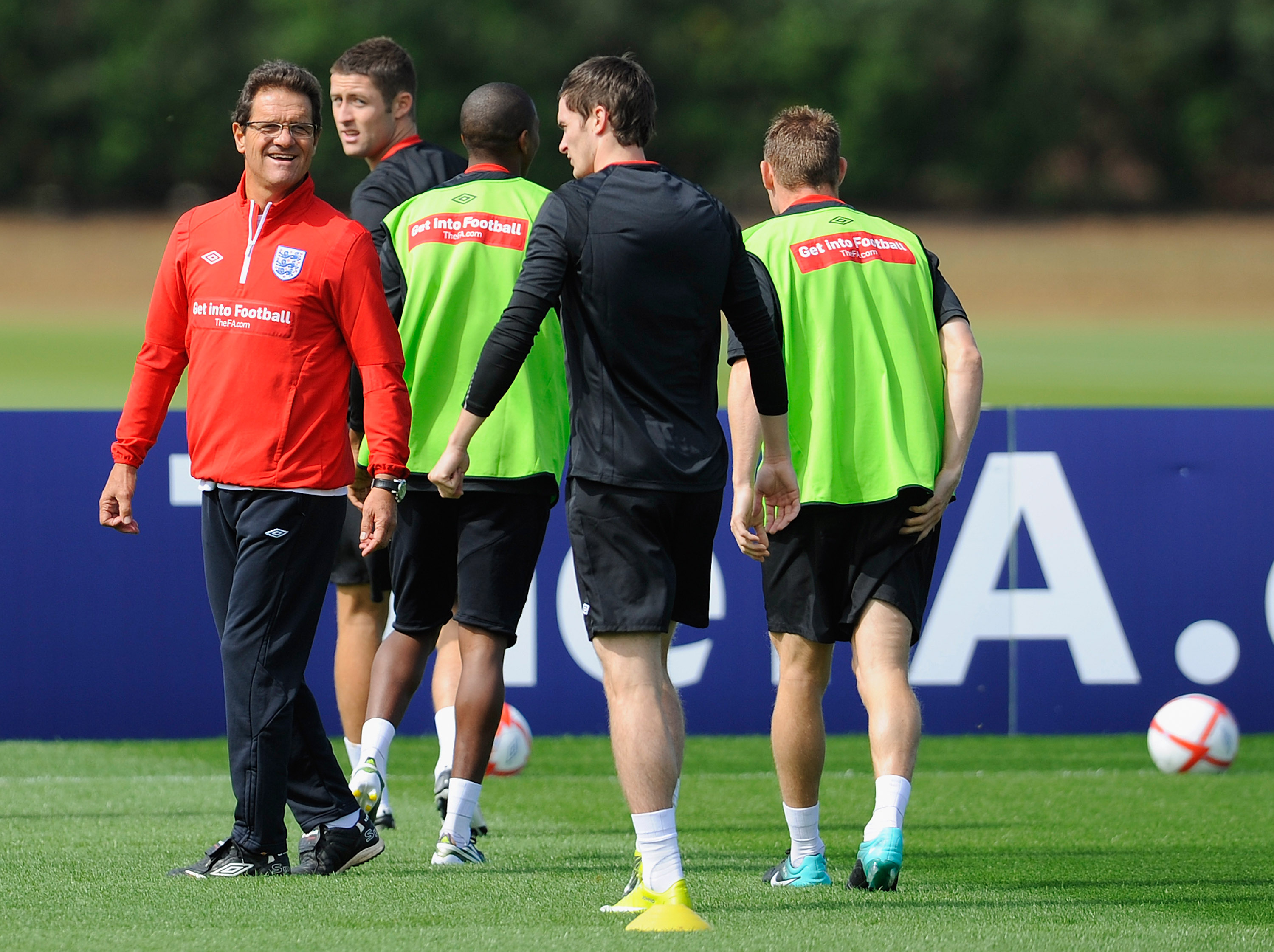 ST ALBANS, ENGLAND - AUGUST 09:  England manger Fabio Capello shares a joke with Adam Johnson during the England training session at London Colney on August 9, 2010 in St Albans, England.  (Photo by Michael Regan/Getty Images)