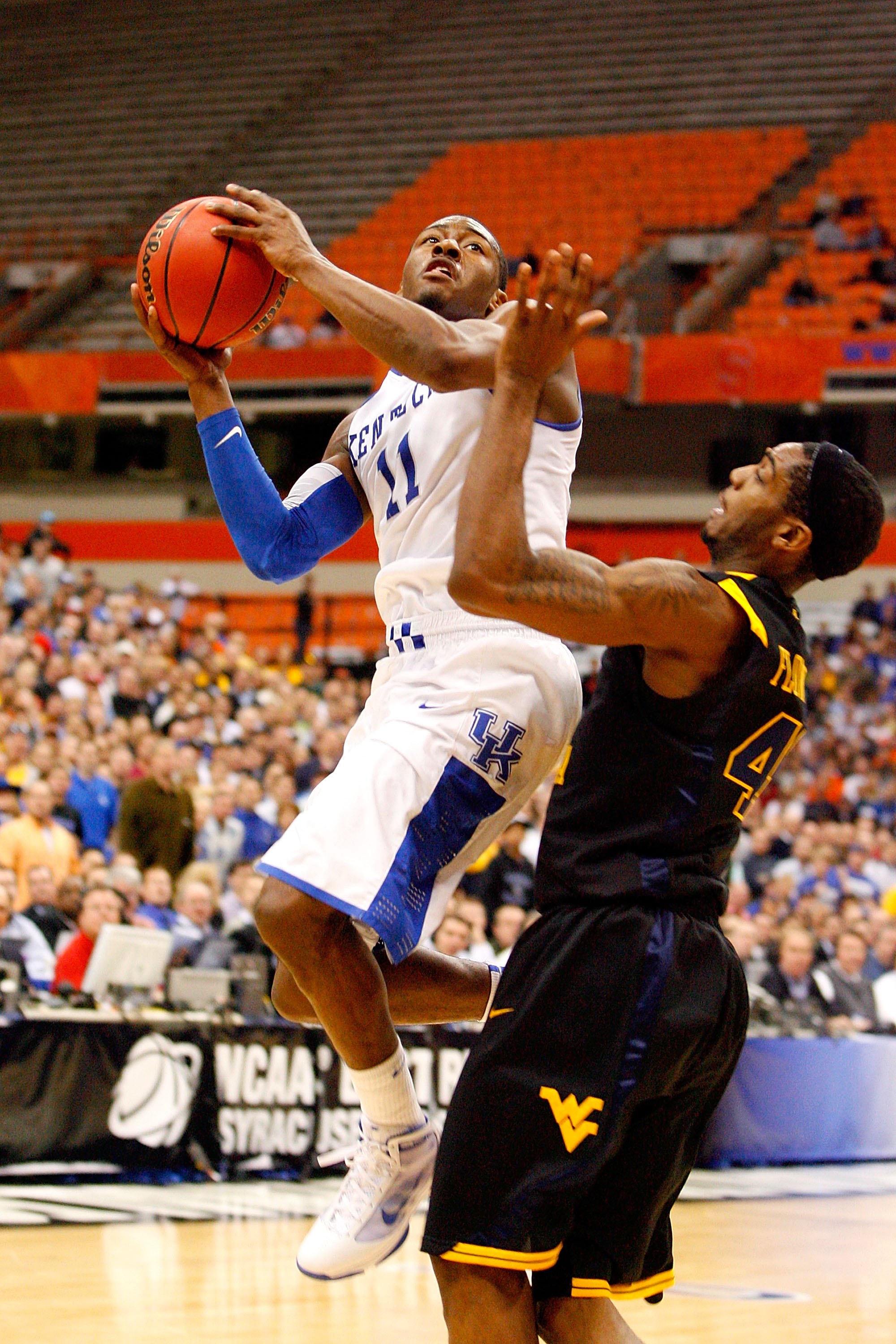 SYRACUSE, NY - MARCH 27: John Wall #11 of the Kentucky Wildcats drives for a shot attempt against Joh Flowers #41 of the West Virginia Mountaineers during the east regional final of the 2010 NCAA men's basketball tournament at the Carrier Dome on March 2