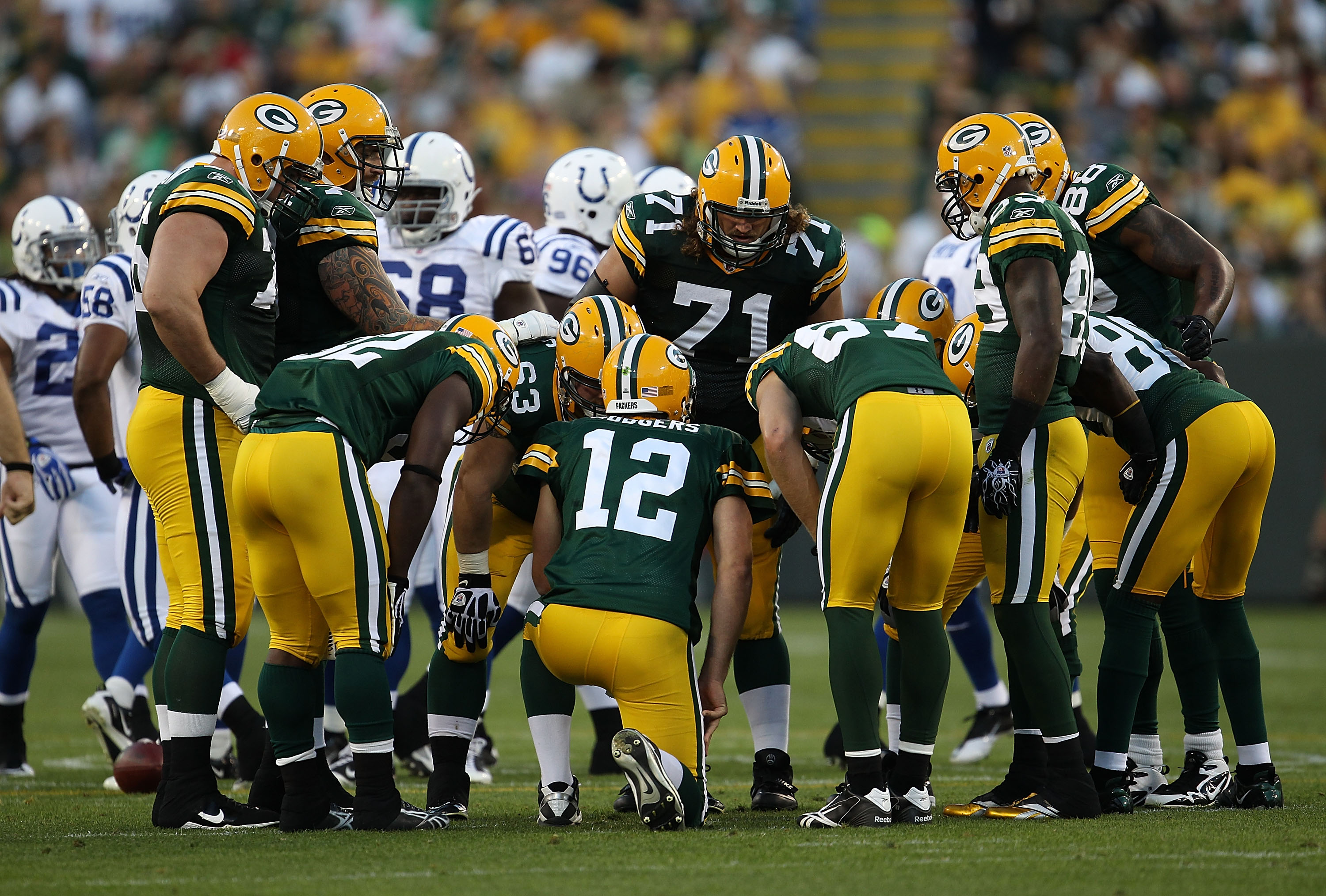 GREEN BAY, WI - AUGUST 26: Aaron Rodgers #12 of the Green Bay Packers calls a play in the huddle against the Indianapolis Colts during a preseason game at Lambeau Field on August 26, 2010 in Green Bay, Wisconsin. The Packers defeated the Colts 59-24. (Pho
