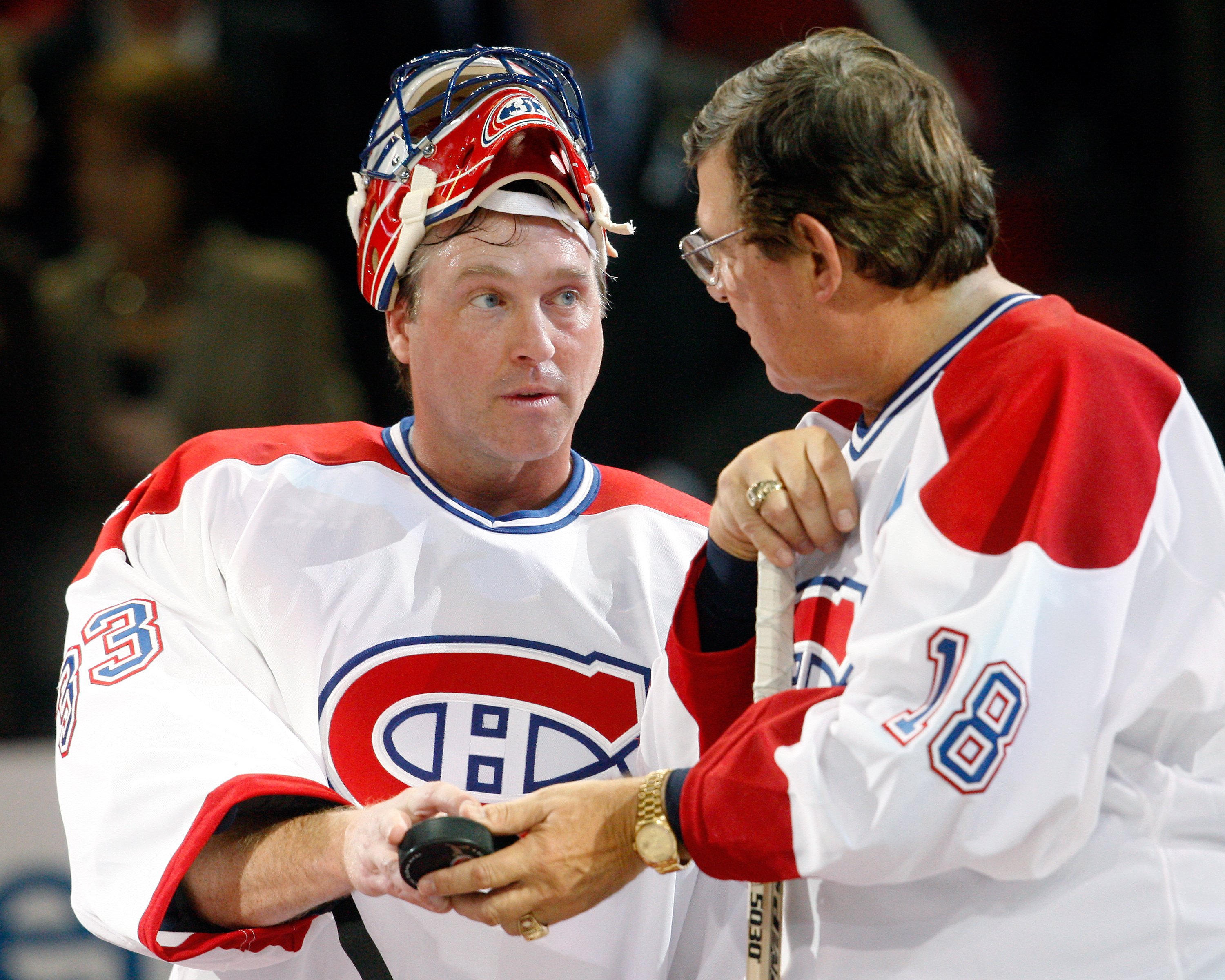 MONTREAL- DECEMBER 4:  Former Montreal Canadiens Serge Savard hands a puck to Patrick Roy during the Centennial Celebration ceremonies prior to the NHL game between the Montreal Canadiens and Boston Bruins on December 4, 2009 at the Bell Centre in Montrea