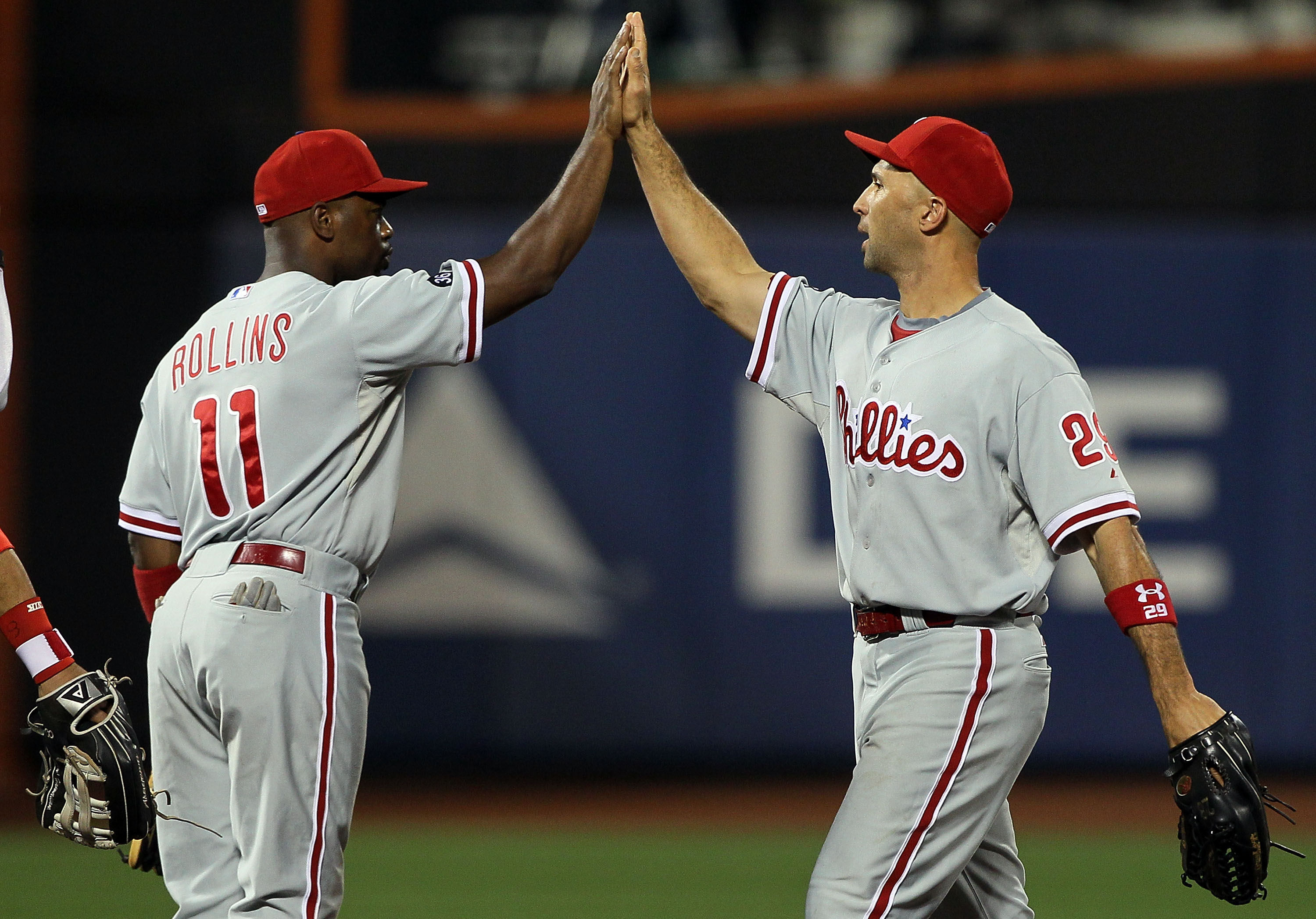NEW YORK - AUGUST 14:  Jimmy Rollins #11 and Raul Ibanez #29 of the Philadelphia Phillies celebrate after defeating the New York Mets on August 14, 2010 at Citi Field in the Flushing neighborhood of the Queens borough of New York City. The Phillies defeat