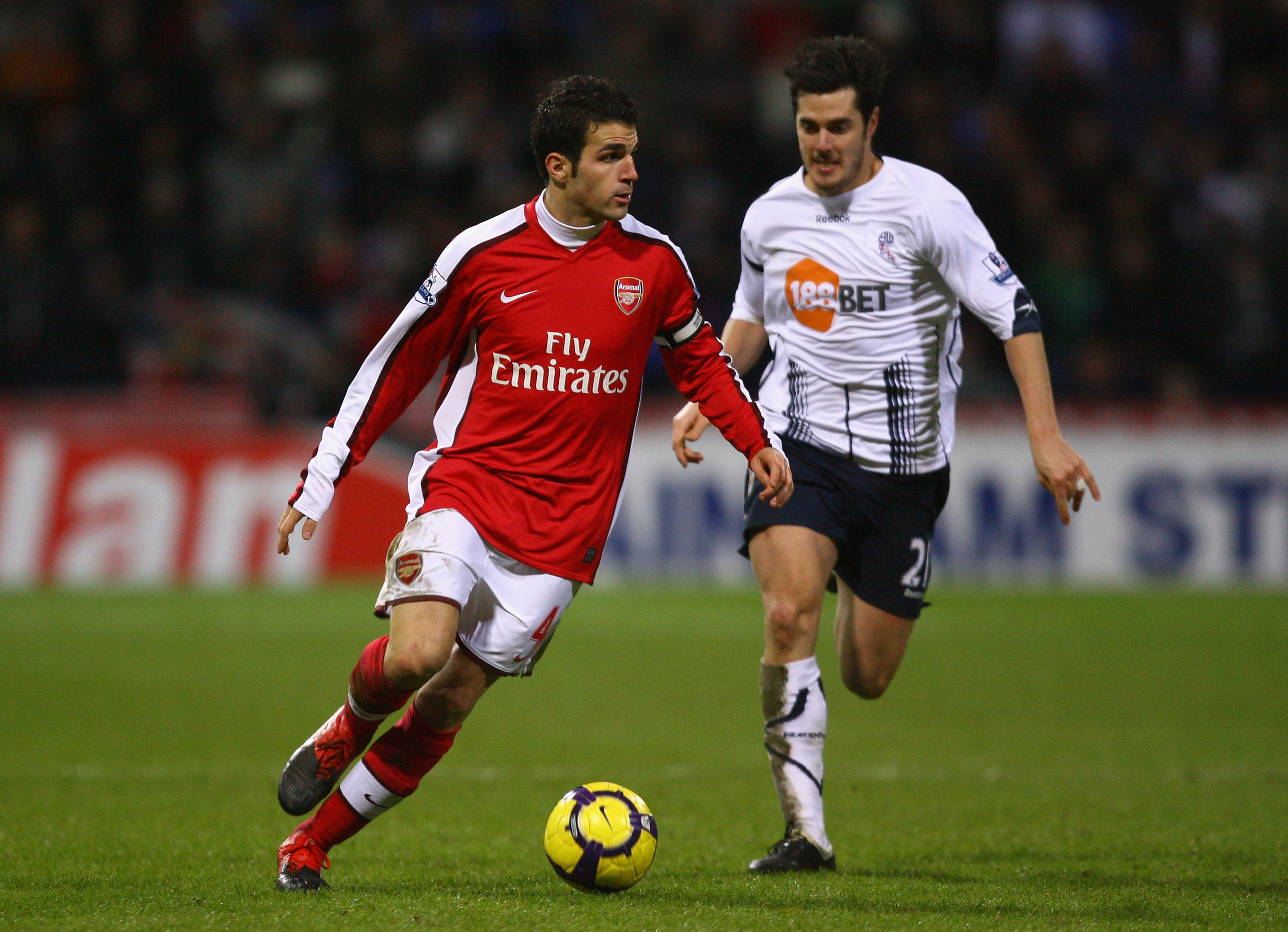 BOLTON, ENGLAND - JANUARY 17:  Cesc Fabregas of Arsenal competes with Tamir Cohen of Bolton Wanderers during the Barclays Premier League match between Bolton Wanderers and Arsenal at the Reebok Stadium on January 17, 2010 in Bolton, England.  (Photo by Al
