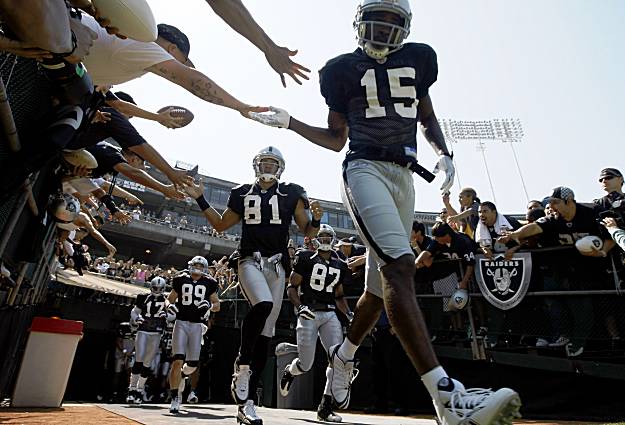Johnnie Lee Higgins and Chaz Schilens lead the Raiders onto the field in 2009.