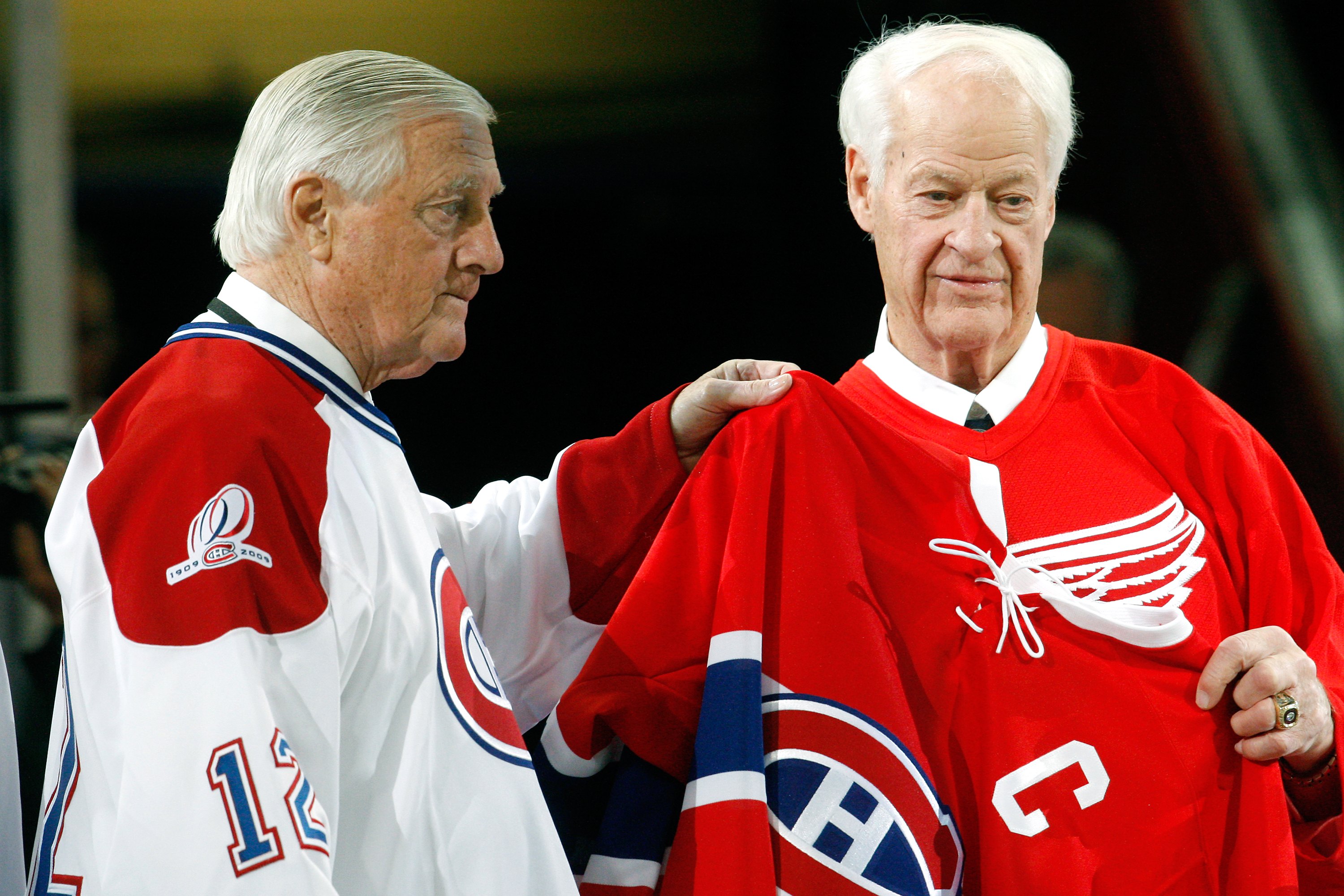 MONTREAL- DECEMBER 4:  Former Montreal Canadien Dickie Moore and Gordie Howe hold up a Maurice Richard Canadiens jersey during the Centennial Celebration ceremonies prior to the NHL game between the Montreal Canadiens and Boston Bruins on December 4, 2009