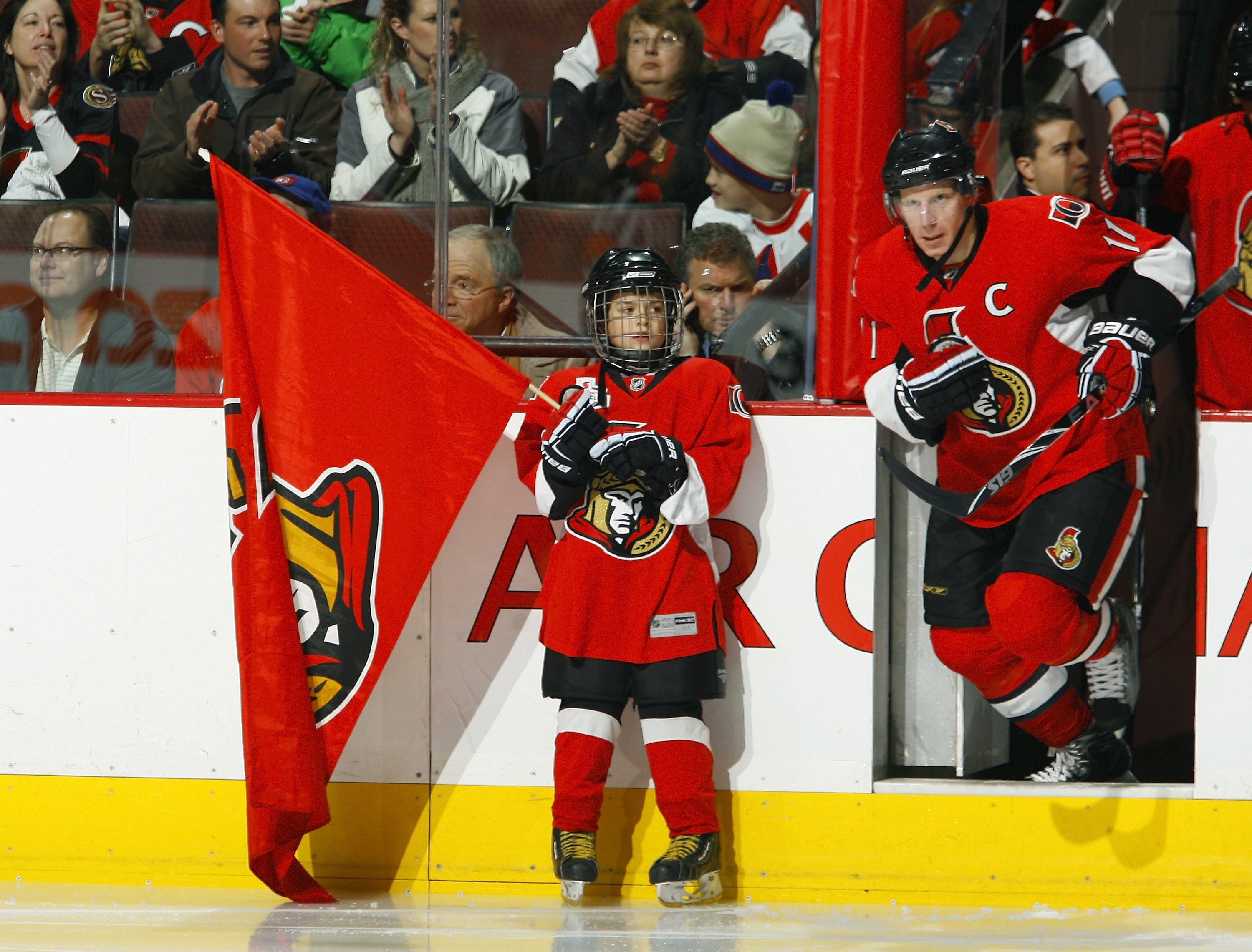 OTTAWA - DECEMBER 8: A young boy holds an Ottawa Senators team flag as Daniel Alfredsson #11 of the Ottawa Senators take the ice before the game against the Montreal Canadiens at Scotiabank Place on December 8, 2009 in Ottawa, Ontario, Canada. The Canadi