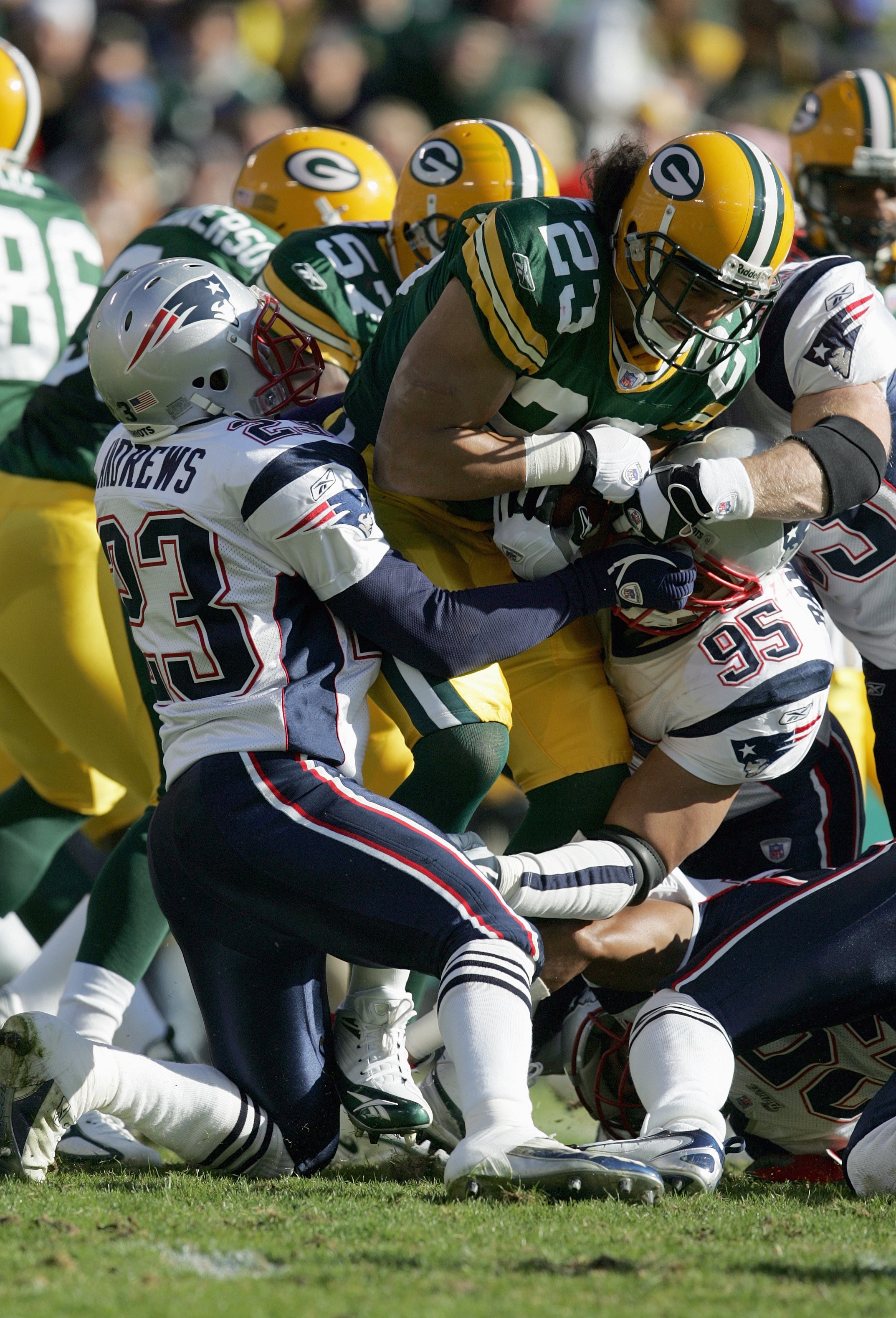 GREEN BAY, WI - NOVEMBER 19:  Noah Herron #23 of the Green Bay Packers grips the ball as he is tackled by  Willie Andrews #23 and Tully Banta- Cain #95 of the New England Patriots on November 19, 2006 at Lambeau Field in Green Bay, Wisconsin. The Patriots