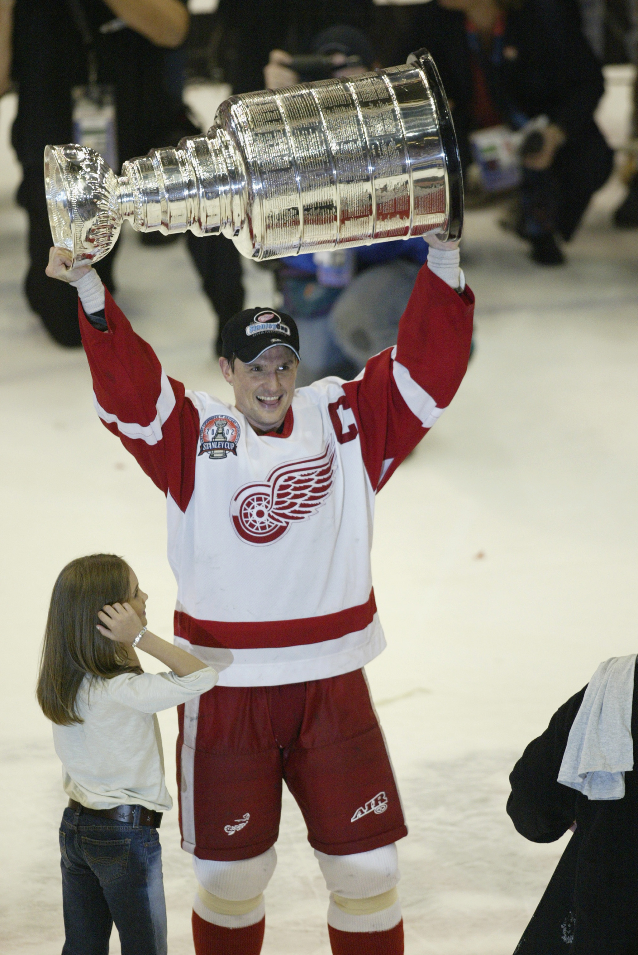 DETROIT, MI - JUNE 13:  Captain Steve Yzerman #19 of the Detroit Red Wings with his daughter Isabella raises the Stanley Cup after defeating the Carolina Hurricanes in game five of the NHL Stanley Cup Finals  on June 13, 2002 at the Joe Louis Arena in Det