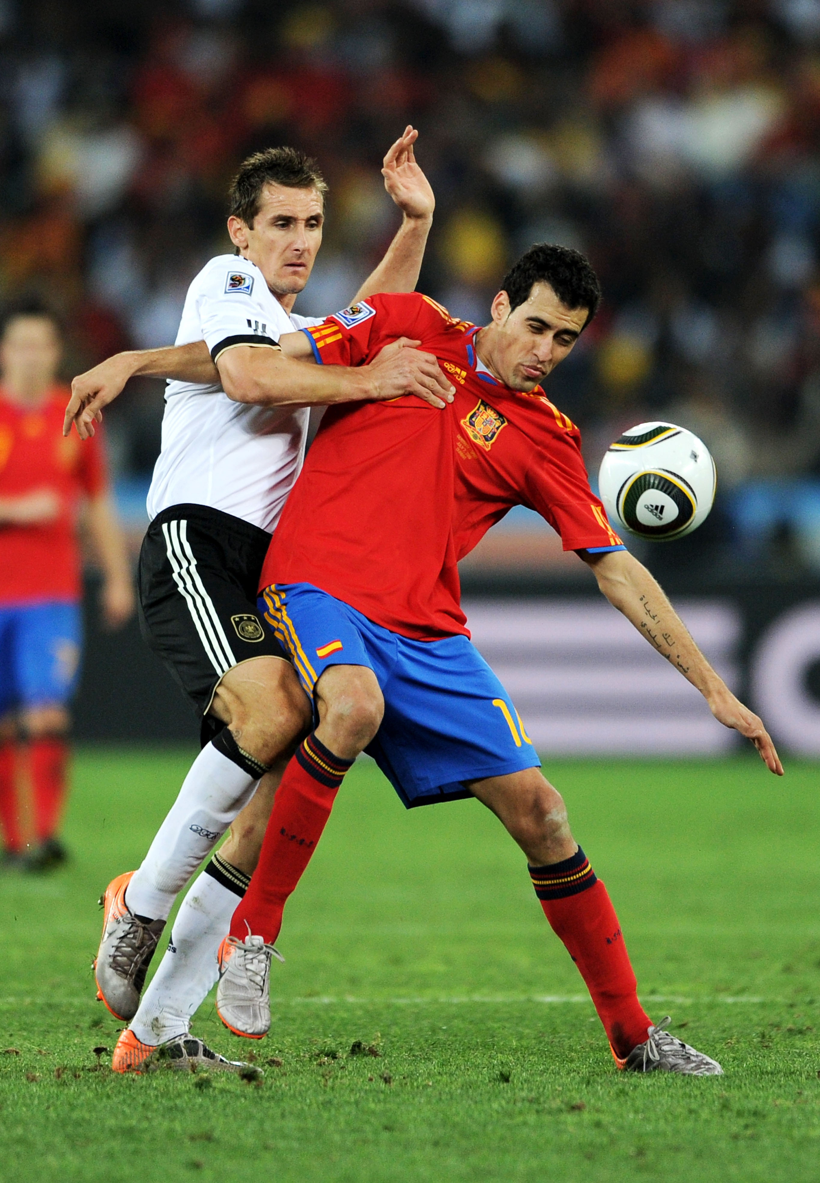 DURBAN, SOUTH AFRICA - JULY 07:  Miroslav Klose of Germany challenges Sergio Busquets of Spain during the 2010 FIFA World Cup South Africa Semi Final match between Germany and Spain at Durban Stadium on July 7, 2010 in Durban, South Africa.  (Photo by Jas
