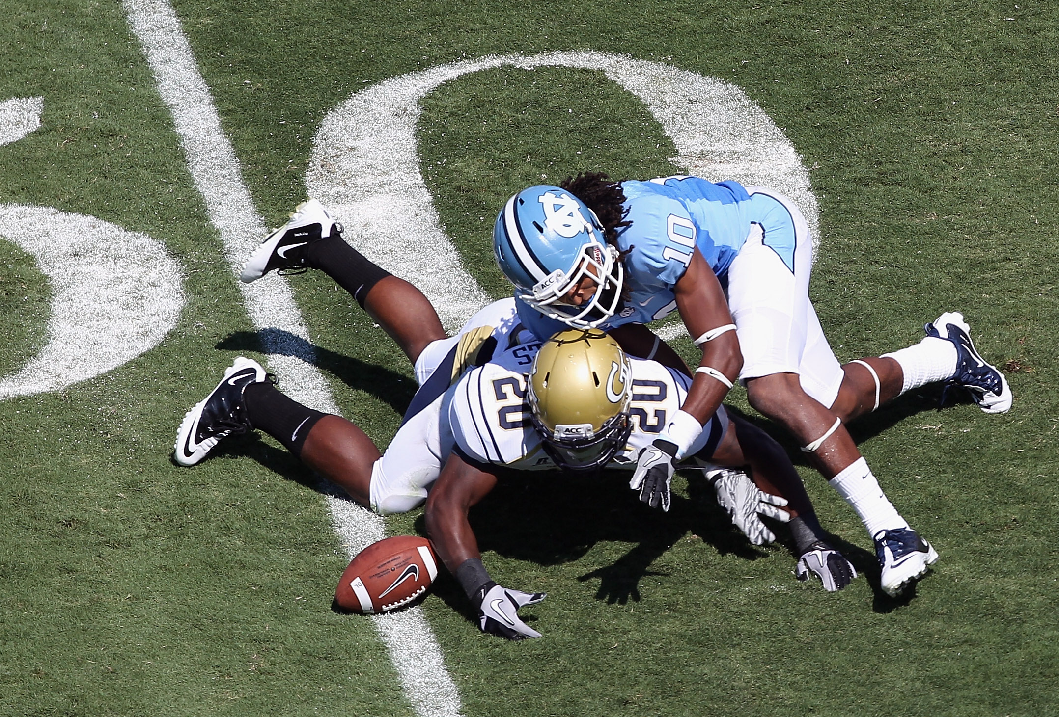 CHAPEL HILL, NC - SEPTEMBER 18: Roddy Jones #20 of the Georgia Tech Yellow Jackets dives for a loose ball with Tre Boston #10 of the North Carolina Tar Heels during their game at Kenan Stadium on September 18, 2010 in Chapel Hill, North Carolina. (Photo