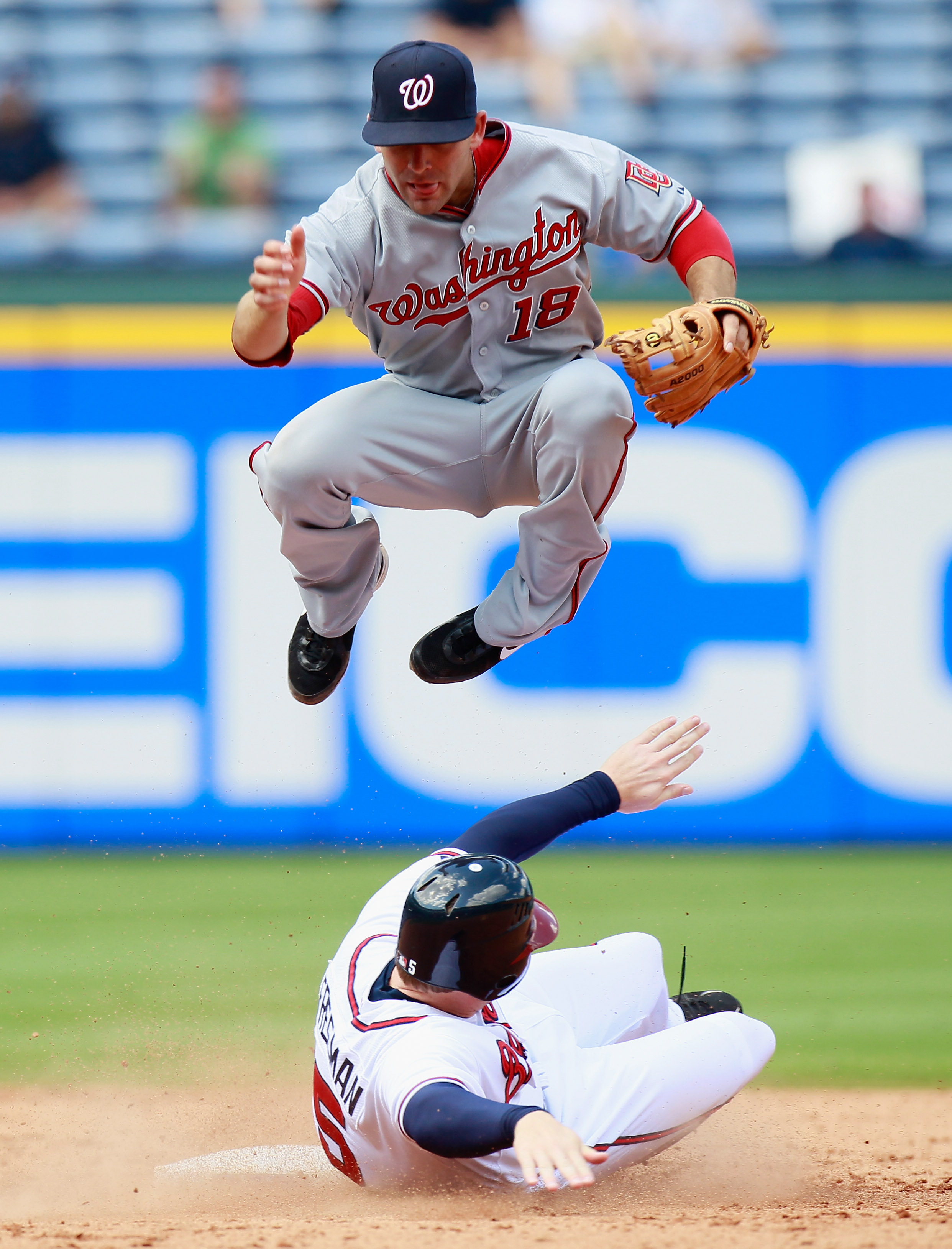 ATLANTA - SEPTEMBER 15:  Danny Espinosa #18 of the Washington Nationals turns a double play as he leaps over Freddie Freeman #5 of the Atlanta Braves at Turner Field on September 15, 2010 in Atlanta, Georgia.  (Photo by Kevin C. Cox/Getty Images)