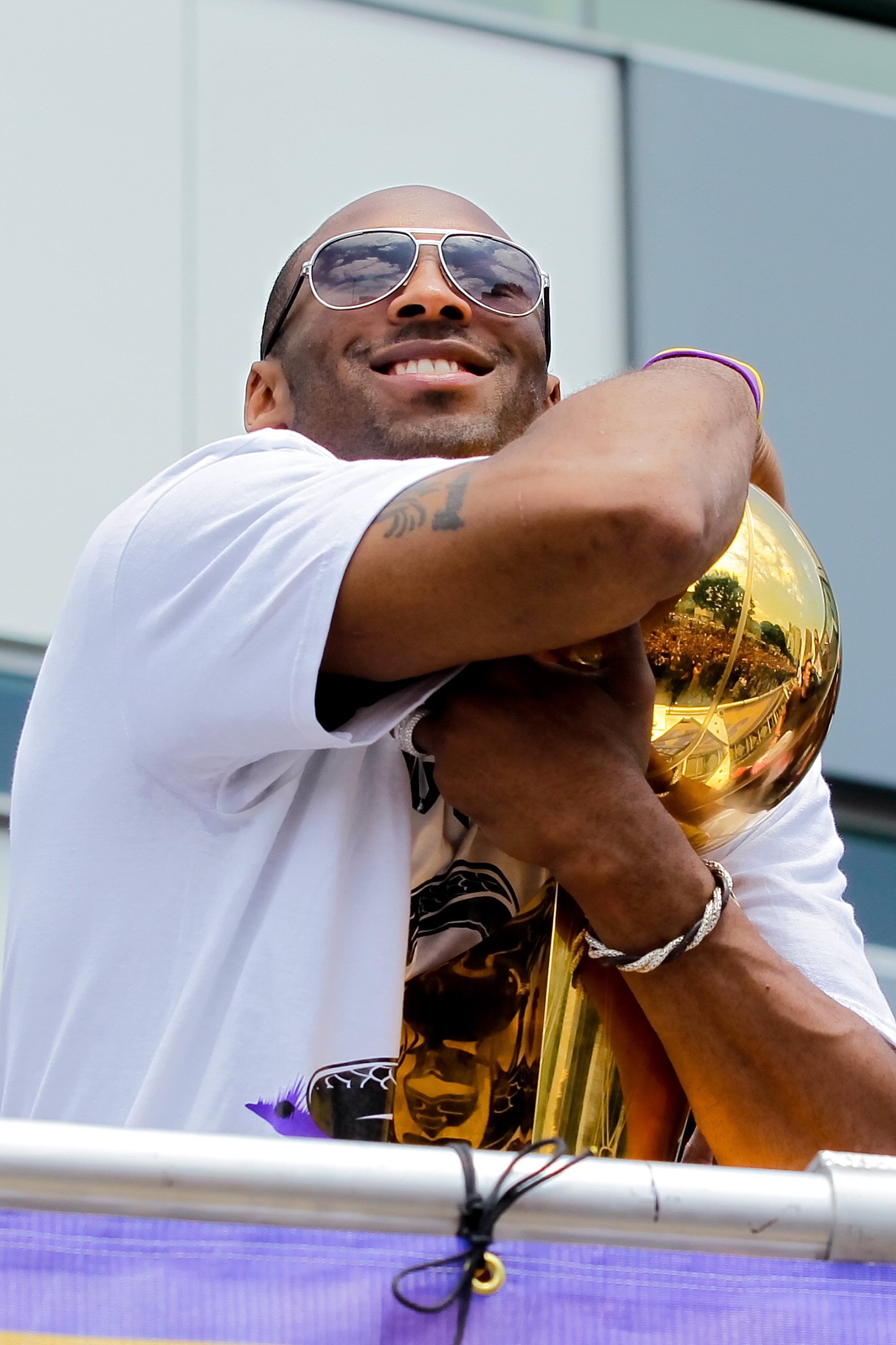 LOS ANGELES, CA - JUNE 21:  Los Angeles Lakers guard Kobe Bryant holds the championship trophy while riding in the victory parade for the the NBA basketball champion team on June 21, 2010 in Los Angeles, California. The Lakers beat the Boston Celtics 87-7
