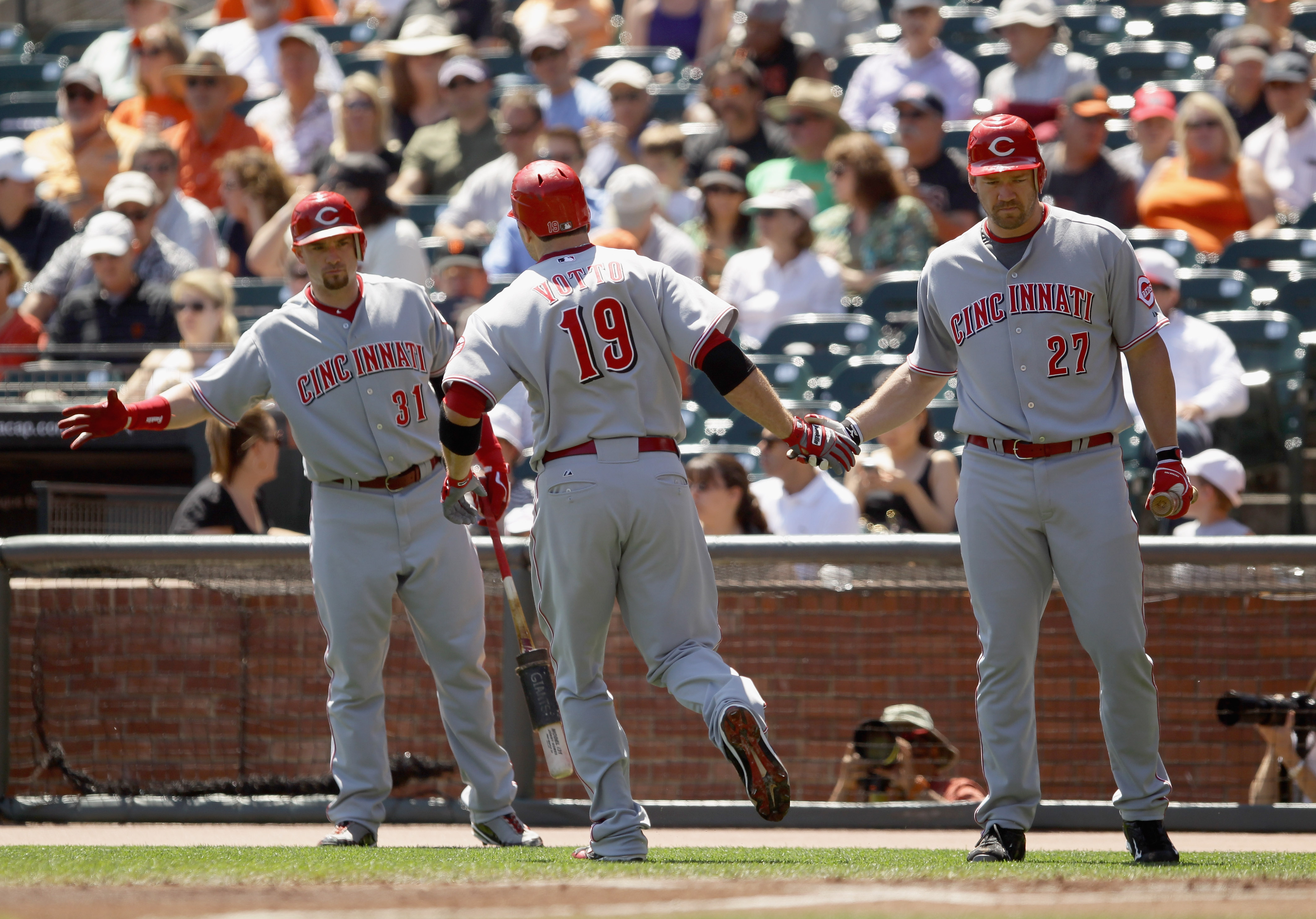 SAN FRANCISCO - AUGUST 25:  Joey Votto #19 of the Cincinnati Reds is congratulated by Scott Rolen #27 and Jonny Gomes #31 after Votto hit a home run in the first inning of their game against the San Francisco Giants at AT&T Park on August 25, 2010 in San