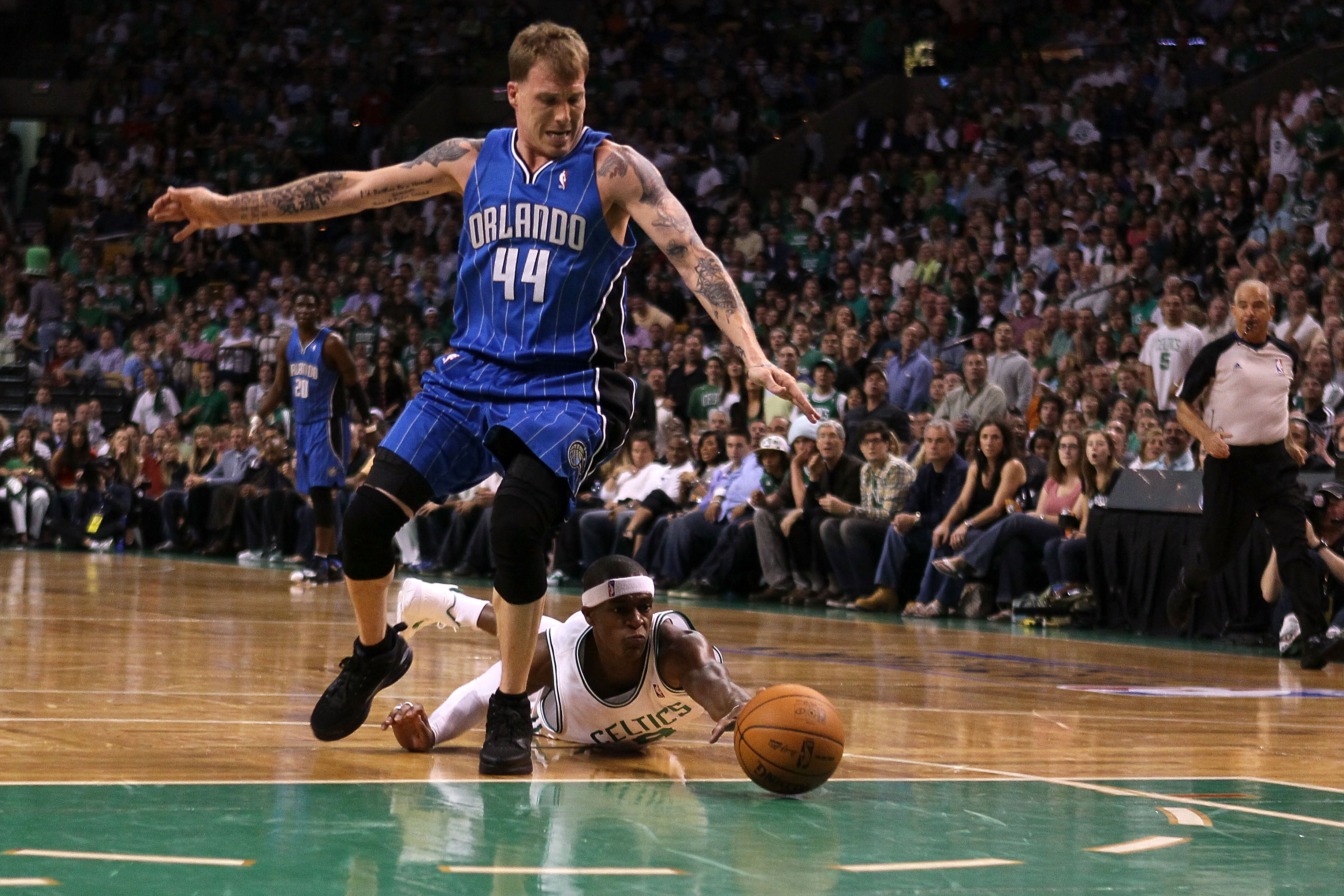 BOSTON - MAY 22:  Rajon Rondo #9 of the Boston Celtics dives for a loose ball against Jason Williams #44 of the Orlando Magic at TD Banknorth Garden in Game Three of the Eastern Conference Finals during the 2010 NBA Playoffs on May 22, 2010 in Boston, Mas