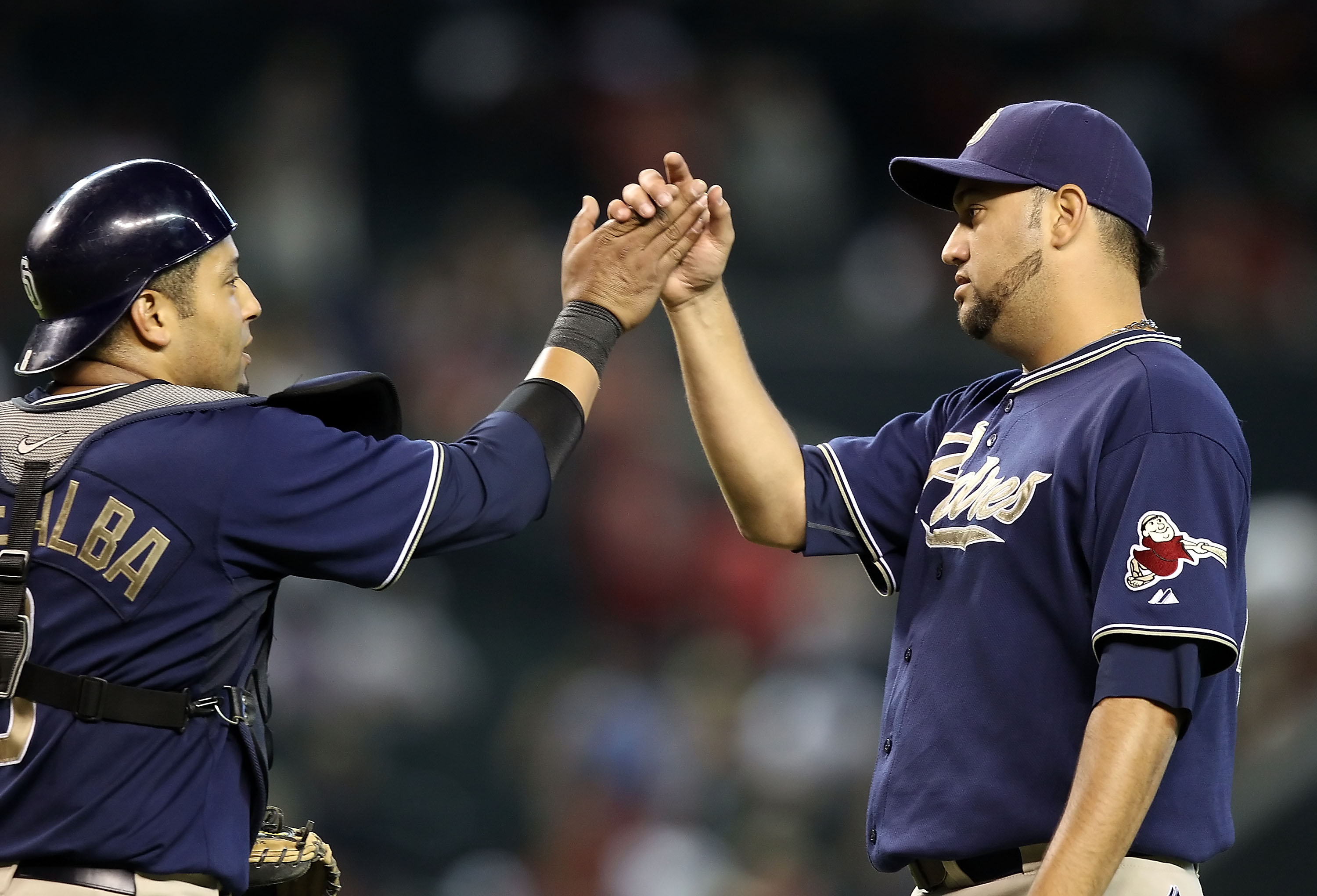 PHOENIX - AUGUST 08:  Relief pitcher Edward Mujica #45 of the San Diego Padres high fives catcher Yorvit Torrealba #8 after defeating the Arizona Diamondbacks in the Major League Baseball game at Chase Field on August 8, 2010 in Phoenix, Arizona.  The Pad