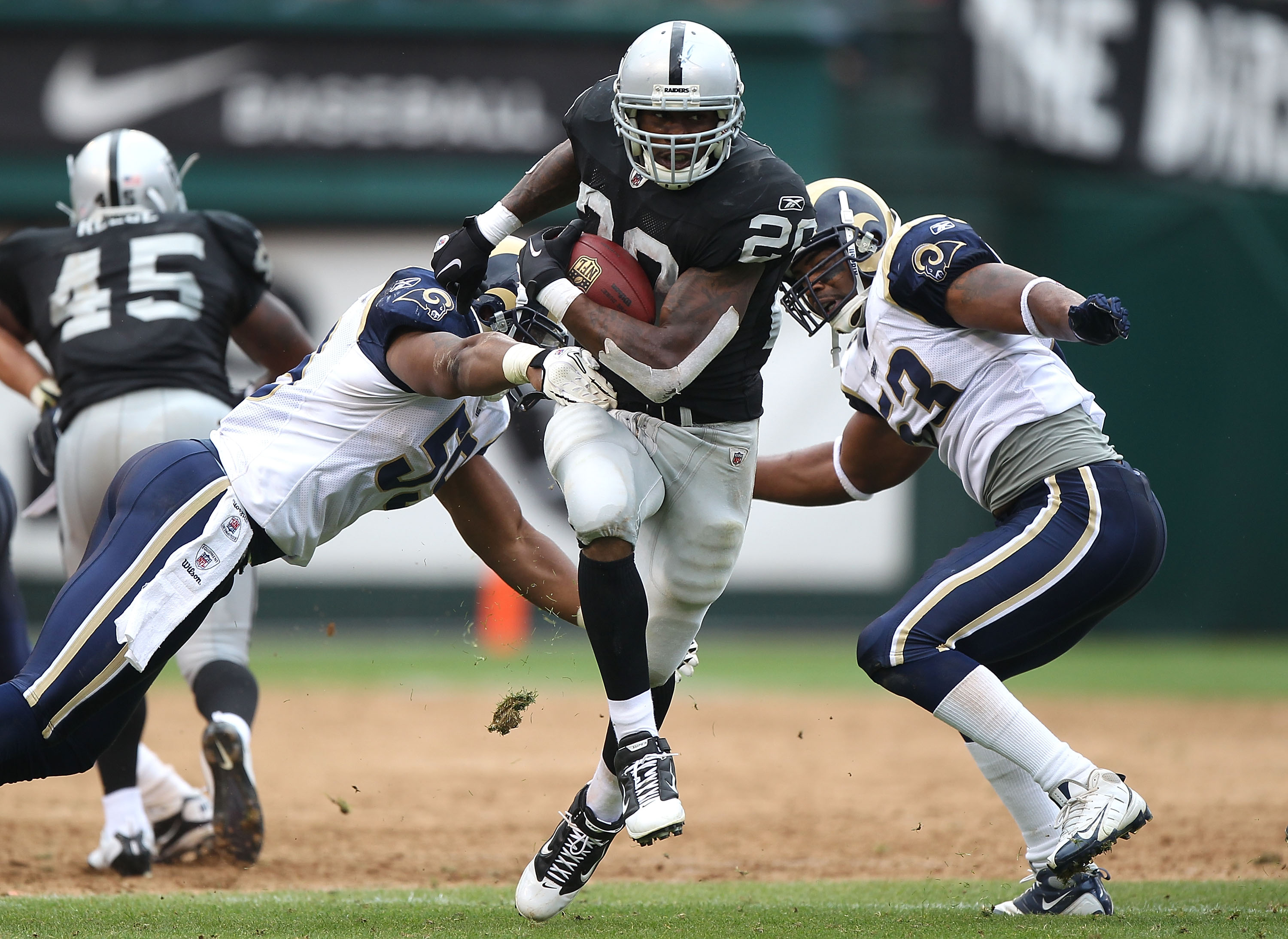 Oakland Raiders running back Darren McFadden (20) pushes off of Kansas City  Chiefs safety Jarrad Page (44) during the first half of an NFL football  game Sunday, Sept. 20, 2009, in Kansas