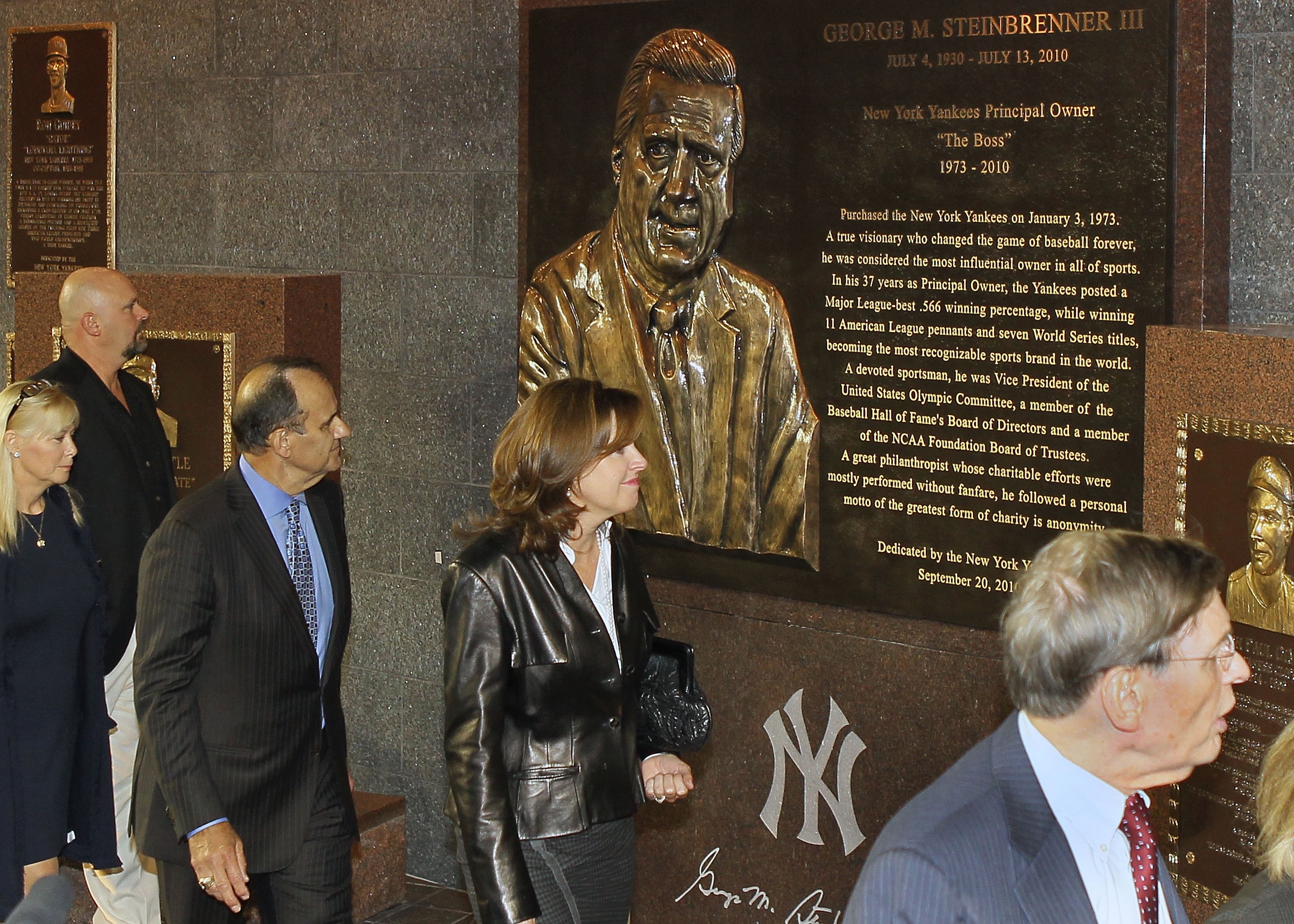 NEW YORK - SEPTEMBER 20:  Former manager of the New York Yankees Joe Torre (3rd L) walks past the monument of late owner George Steinbrenner with his wife Ali prior to the game against the Tampa Bay Rays on September 20, 2010 at Yankee Stadium in the Bron