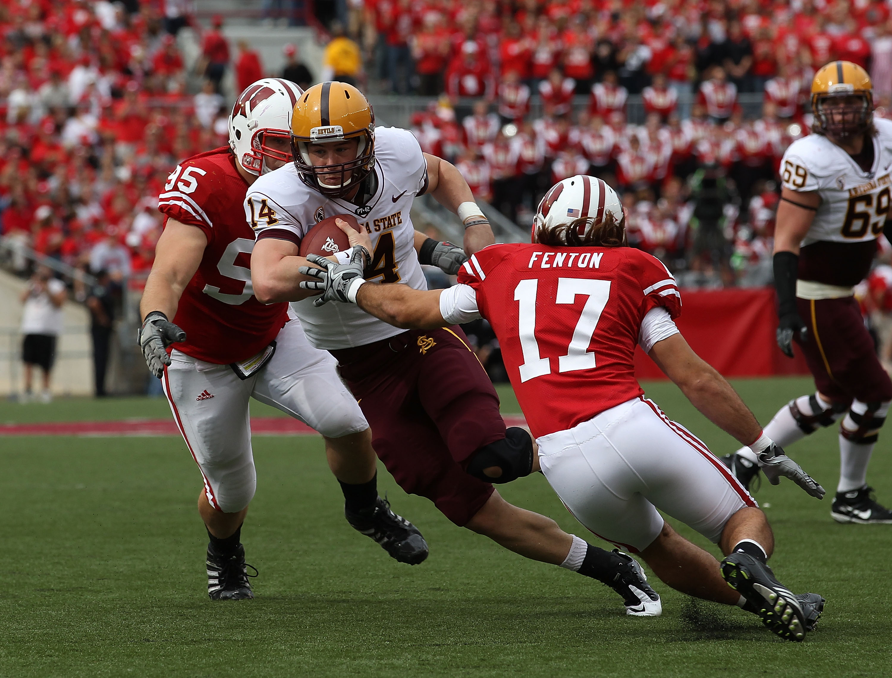 MADISON, WI - SEPTEMBER 18: Steven Threet #14 of the Arizona State Sun Devils tries to move between Patrick Butrym #95 and A.J. Fenton #17 of the Wisconsin Badgers at Camp Randall Stadium on September 18, 2010 in Madison, Wisconsin. Wisconsin defeated Ari