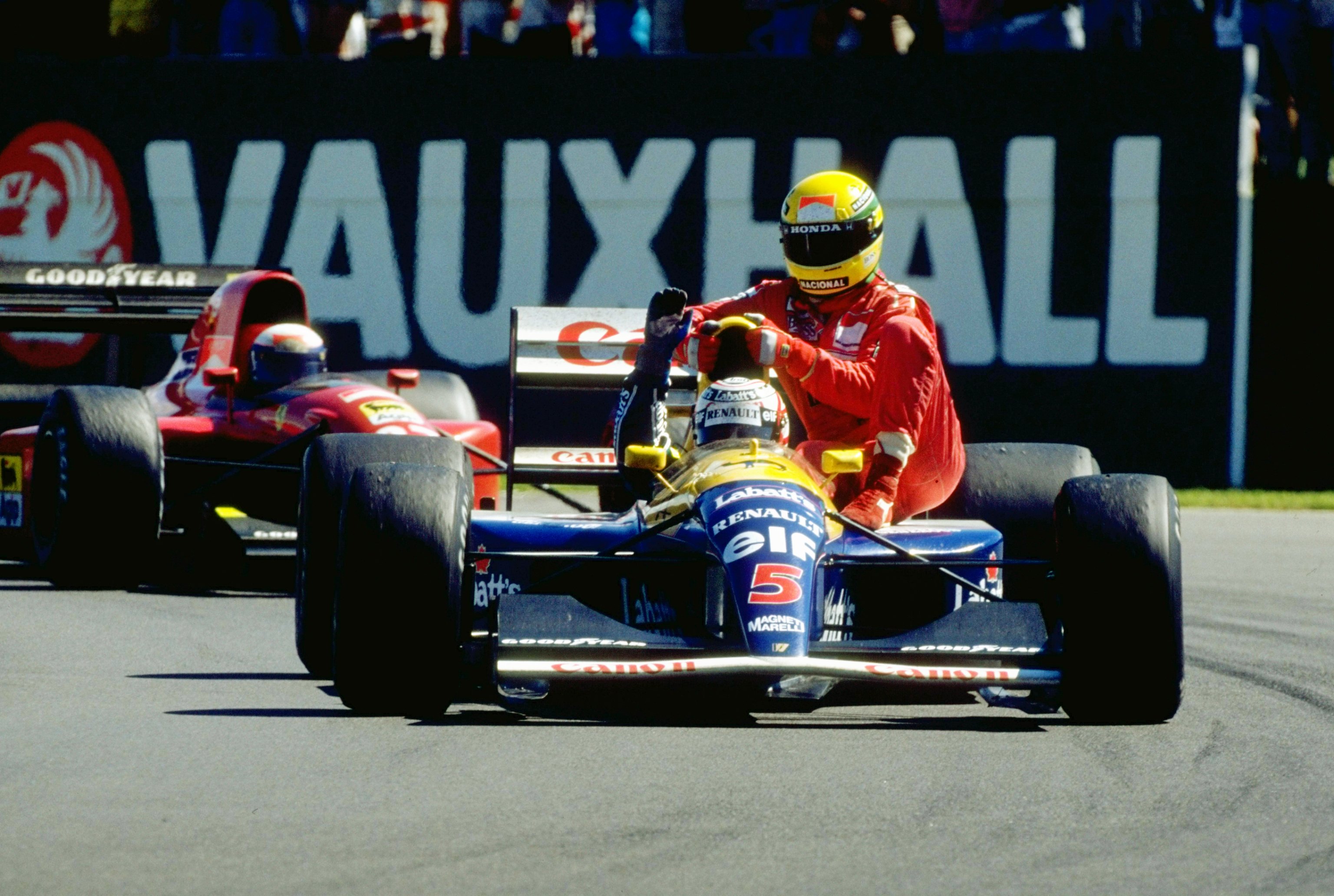 1991:  Williams Renault driver Nigel Mansell of Great Britain gives McLaren Honda driver Ayrton Senna of Brazil a lift home after the British Grand Prix at the Silverstone circuit in England. Mansell finished in first place and Senna retired from the race