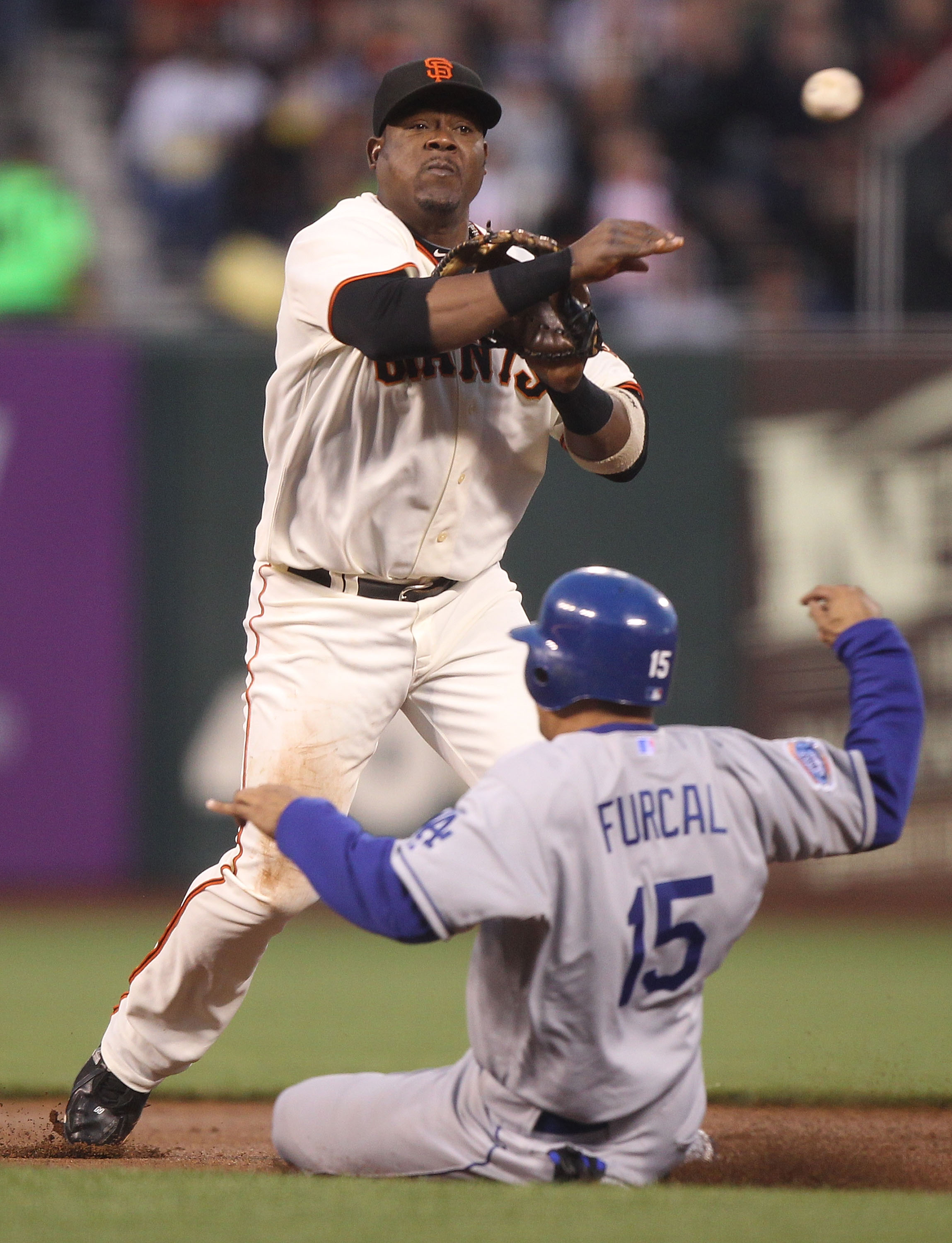 SAN FRANCISCO - SEPTEMBER 14:  Juan Uribe #5 of the San Francisco Giants throws to first as Rafael Furcal #15 of the Los Angeles Dodgers slides into second on a double play ball hit by Andre Ethier in the first inning during a Major League Baseball game a