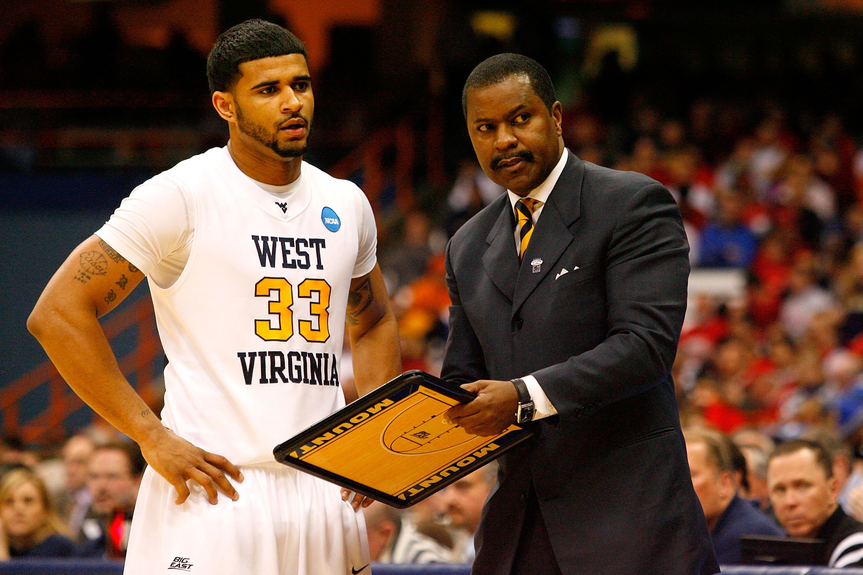 SYRACUSE, NY - MARCH 25: Assistant coach Larry Harrison and Casey Mitchell #33 of the West Virginia Mountaineers talk during a timeout against the Washington Huskies during the east regional semifinal of the 2010 NCAA men's basketball tournament at the C