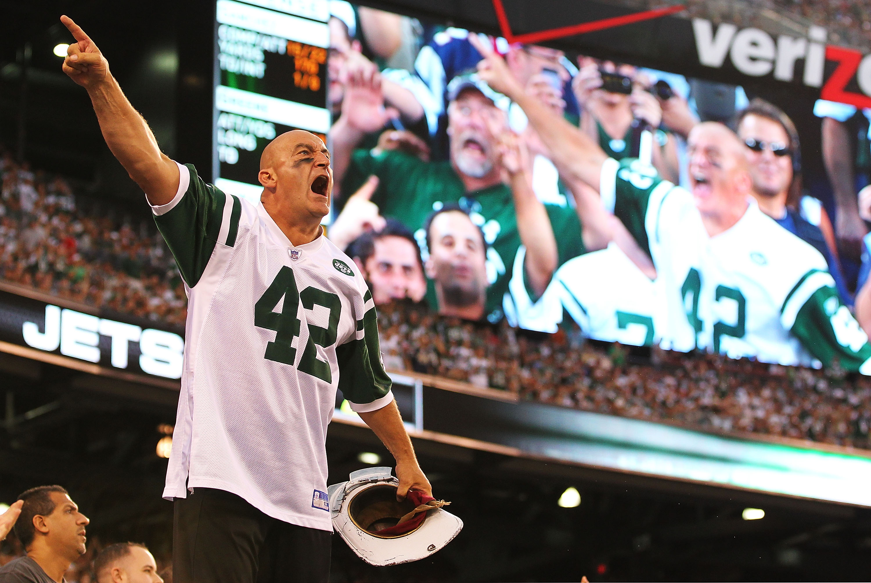 EAST RUTHERFORD, NJ - SEPTEMBER 19:  New York Jets fan Fireman Ed Anzalone leads the crowd in a cheer against the New England Patriots during their  game on September 19, 2010 at the New Meadowlands Stadium  in East Rutherford, New Jersey.  (Photo by Al B