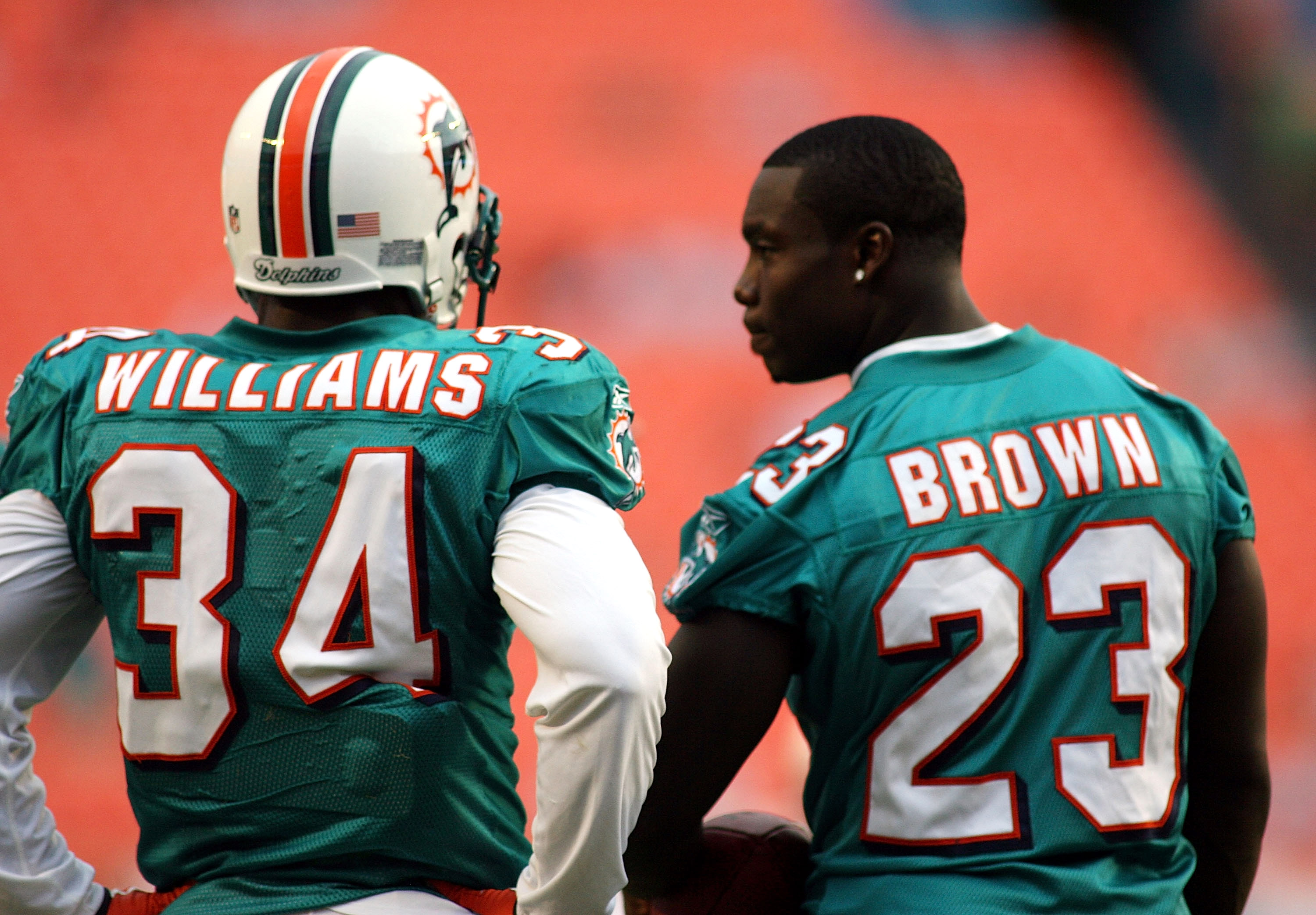 Miami Dolphins running back Ricky Williams (34) runs by a leaping  Pittsburgh Steelers Troy Polamalu (43)