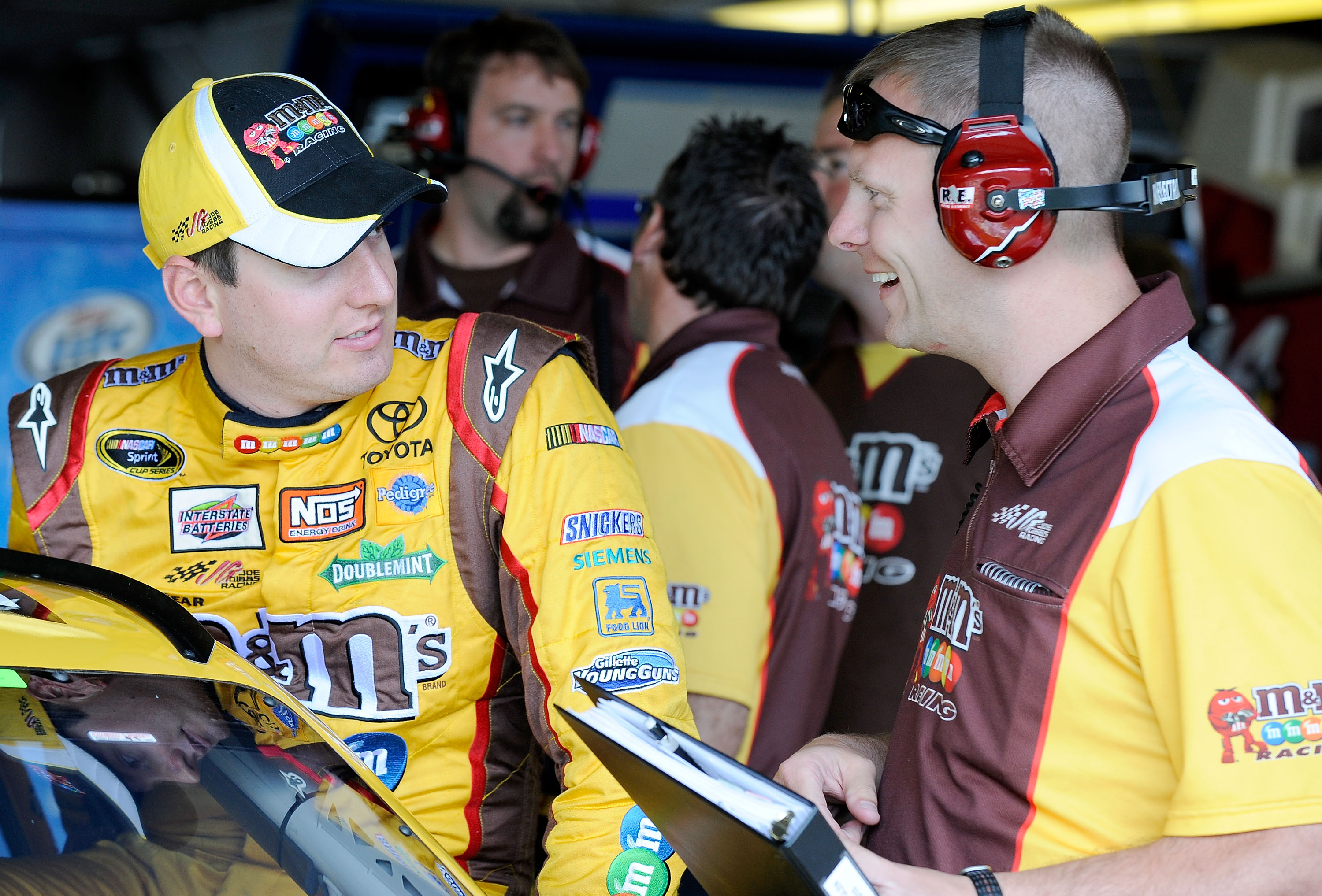 WATKINS GLEN, NY - AUGUST 06:  Kyle Busch (L), driver of the #18 M&M's Toyota, talks with his crew chief Dave Rogers in the garage during practice for the NASCAR Heluva Good! Sour Cream Dips at The Glen on August 6, 2010 in Watkins Glen, New York.  (Photo