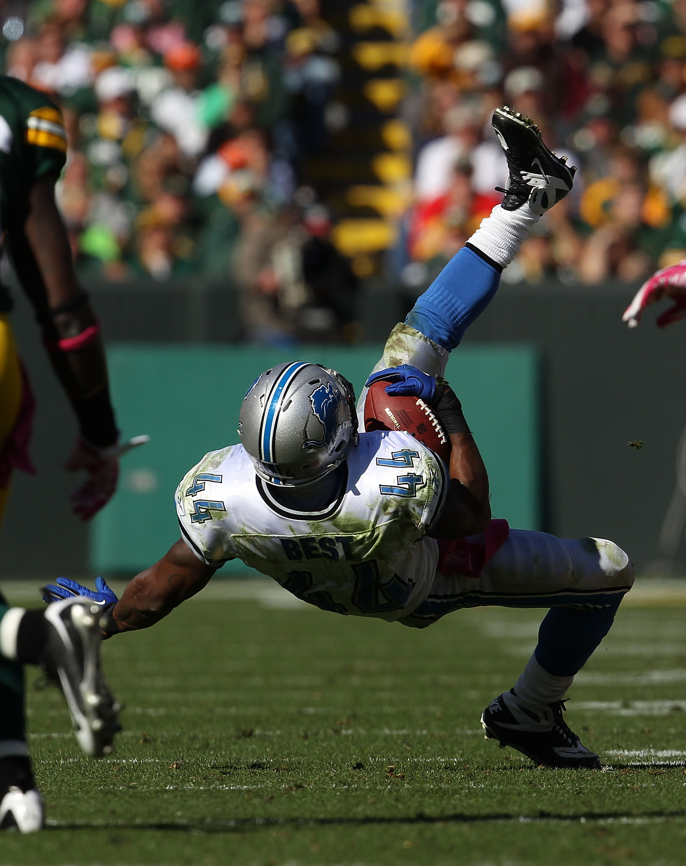 GREEN BAY, WI - OCTOBER 03: Rahvid Best #44 of the Detroit Lions flips in the air after being tackled by Charles Woodson of the Green Bay Packers at Lambeau Field on October 3, 2010 in Green Bay, Wisconsin. The Packers defeated the Lions 28-26.  (Photo by