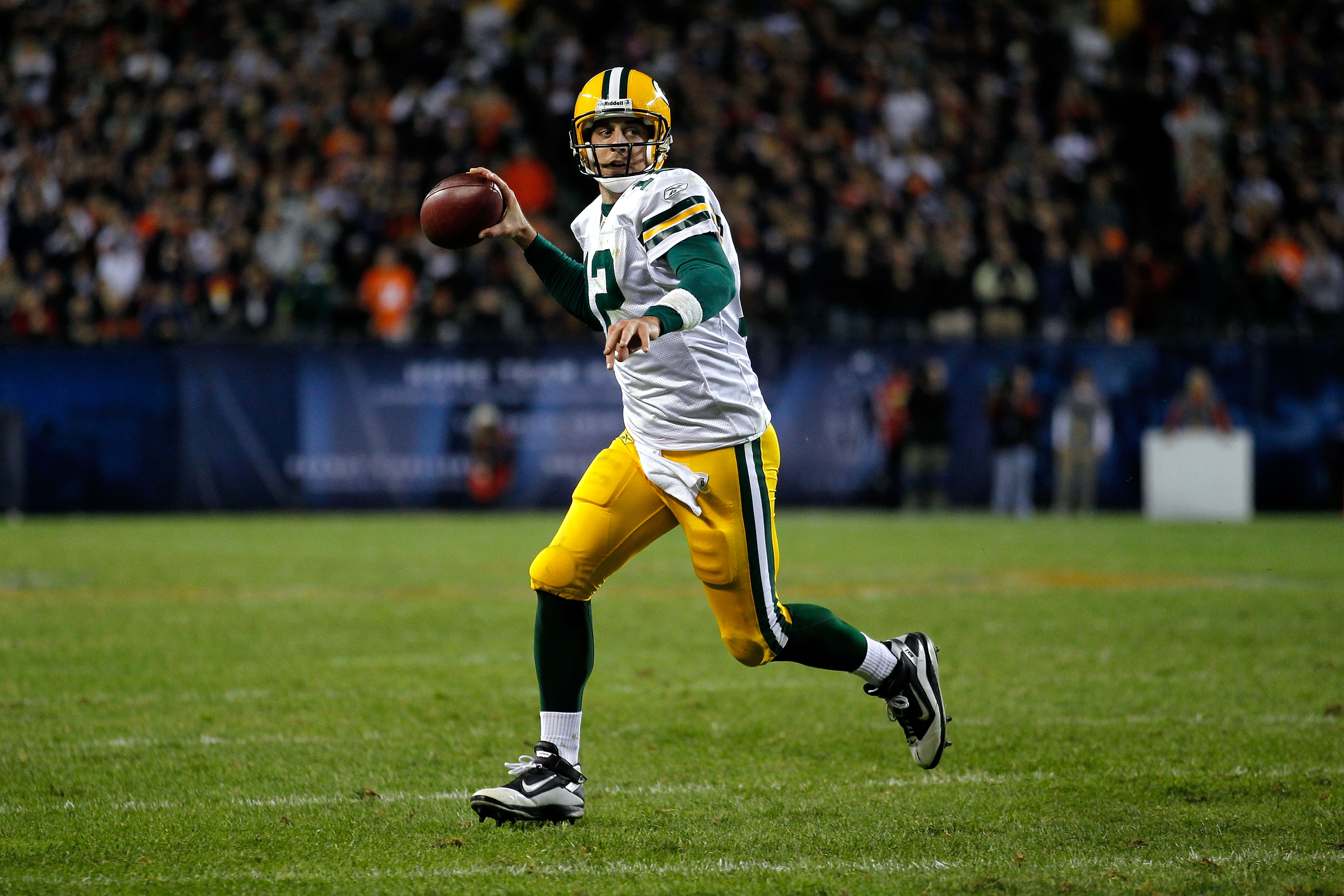CHICAGO - SEPTEMBER 27:  Quarterback Aaron Rodgers #12 of the Green Bay Packers rolls out to pass against the Chicago Bears at Soldier Field on September 27, 2010 in Chicago, Illinois.  (Photo by Jonathan Daniel/Getty Images)