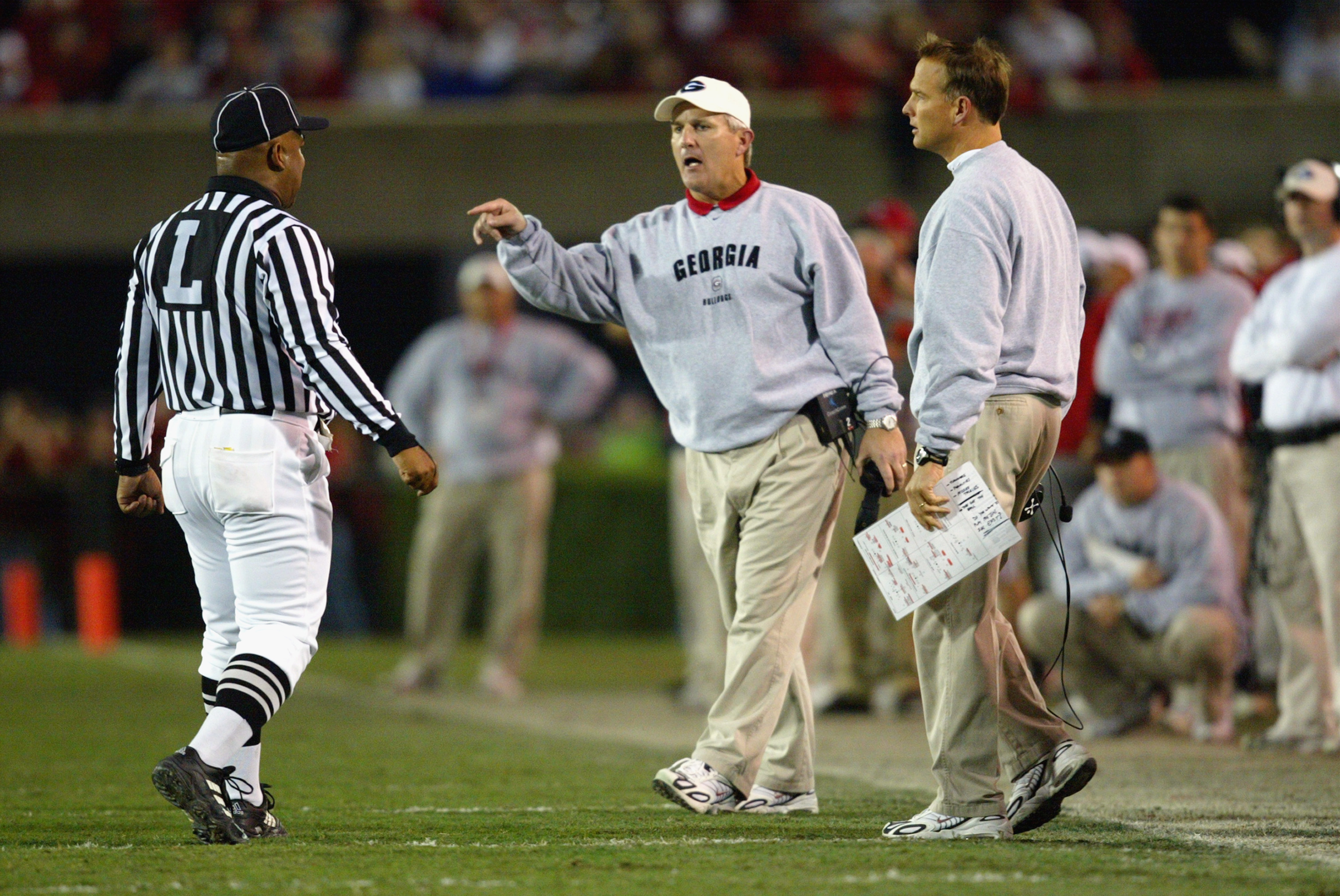 ATHENS, GA - NOVEMBER 9:  Offensive coordinator Neil Callaway (center) and head coach Mark Richt (right) of the University of Georgia Bulldogs argue with a referee during the SEC game against the University of Mississippi Rebels at Sanford Stadium on Nove