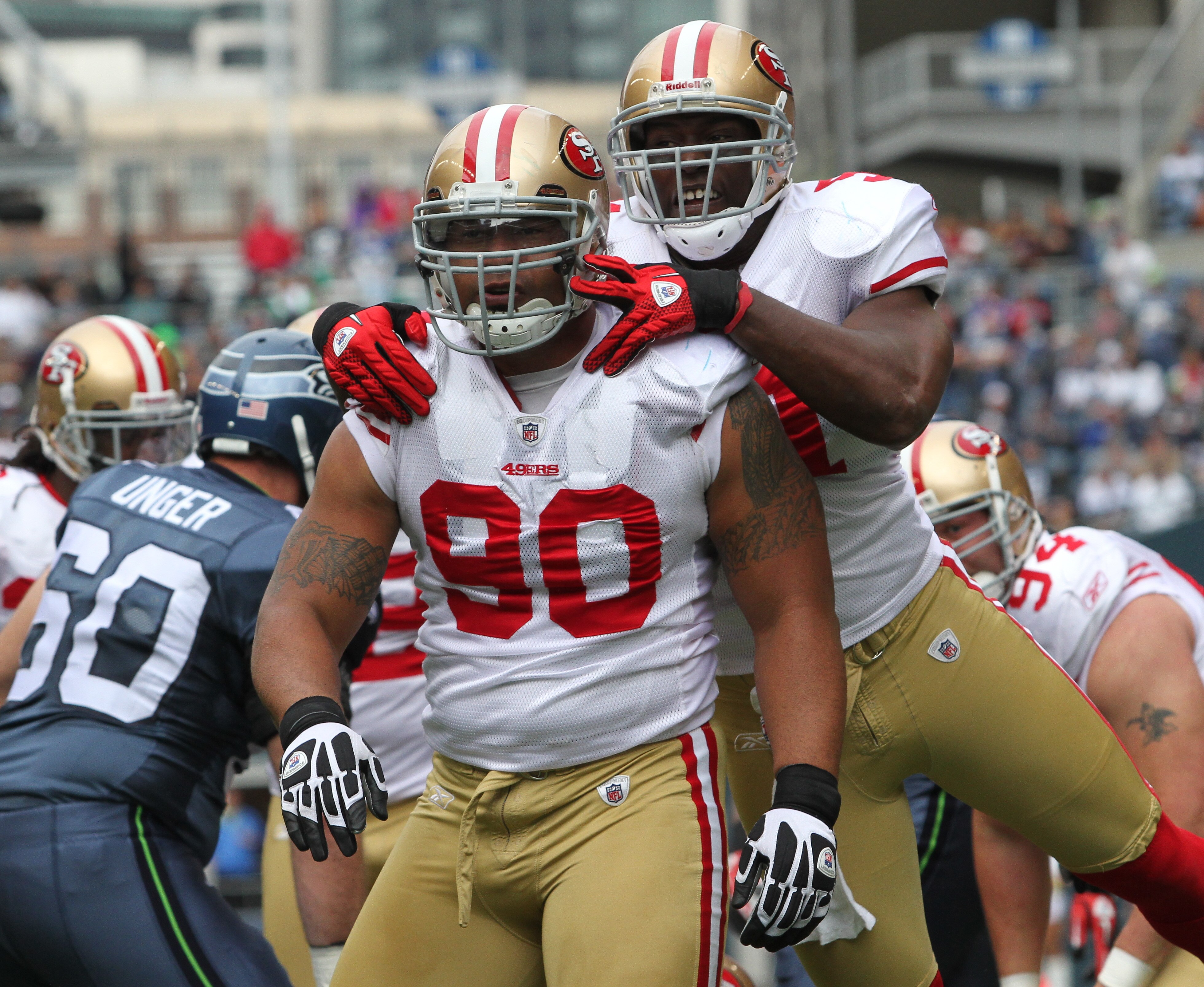 SEATTLE - SEPTEMBER 12:  Defensive tackle Isaac Sopoaga #90 of the San Francisco 49ers is congratulated by Takeo Spikes #51 after tackling Justin Forsett #20 during the NFL season opener against the Seattle Seahawks at Qwest Field on September 12, 2010 in