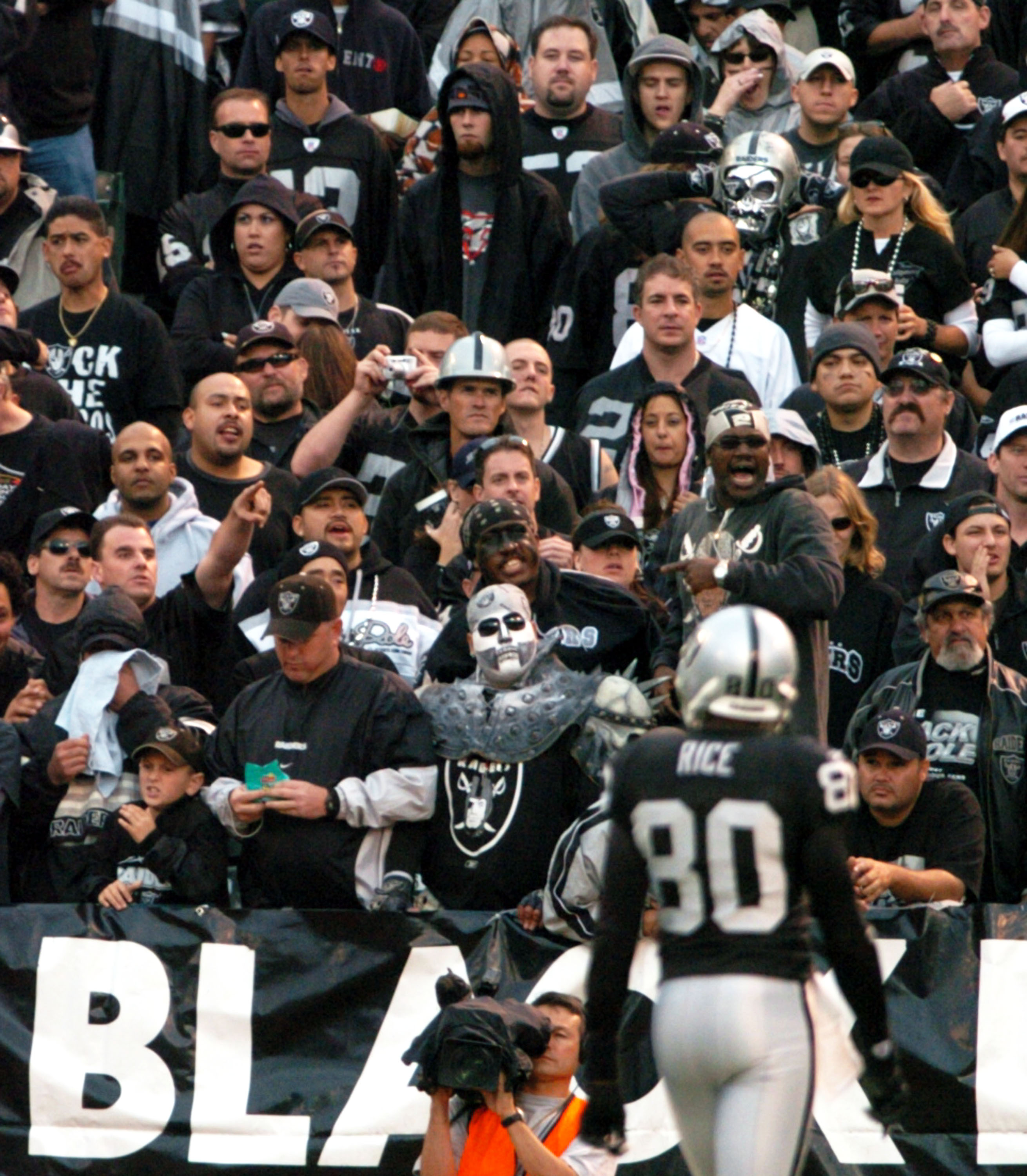 OAKLAND, CA - OCTOBER 17:  Fans in the black hole cheer for Jerry Rice #80 of the Oakland Raiders at the Network Associates Coliseum on October 17, 2004 in Oakland, California.  It turned out to be his last game in a Raider uniform as he was traded to the