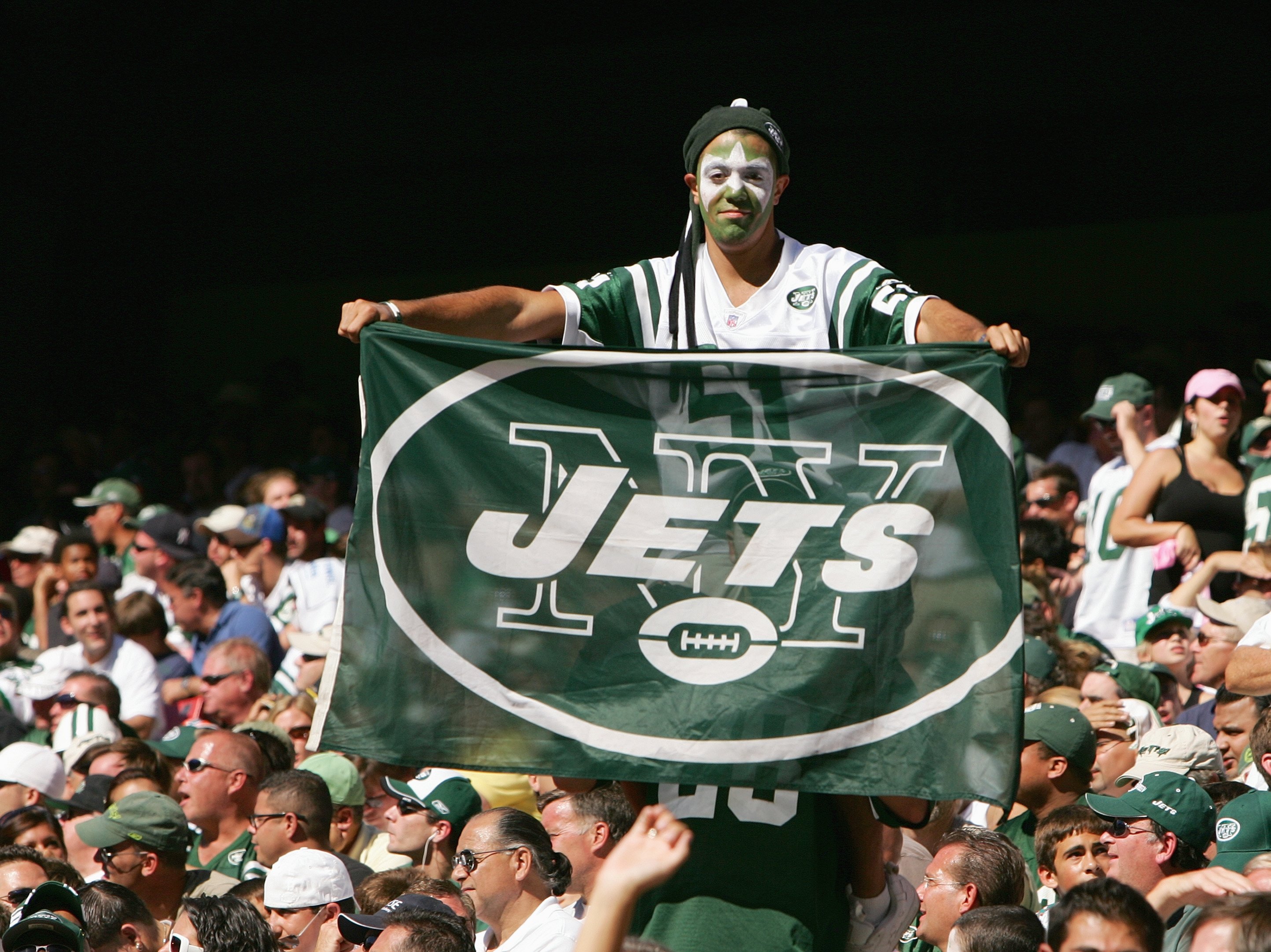 EAST RUTHERFORD, NJ - SEPTEMBER 23: A fan of the New York Jets holds up a Jets flag during the game against the Miami Dolphins on September 23, 2007 at Giants Stadium in East Rutherford, New Jersey. The Jets defeated the Dolphins 31-28. (Photo by Al Bello