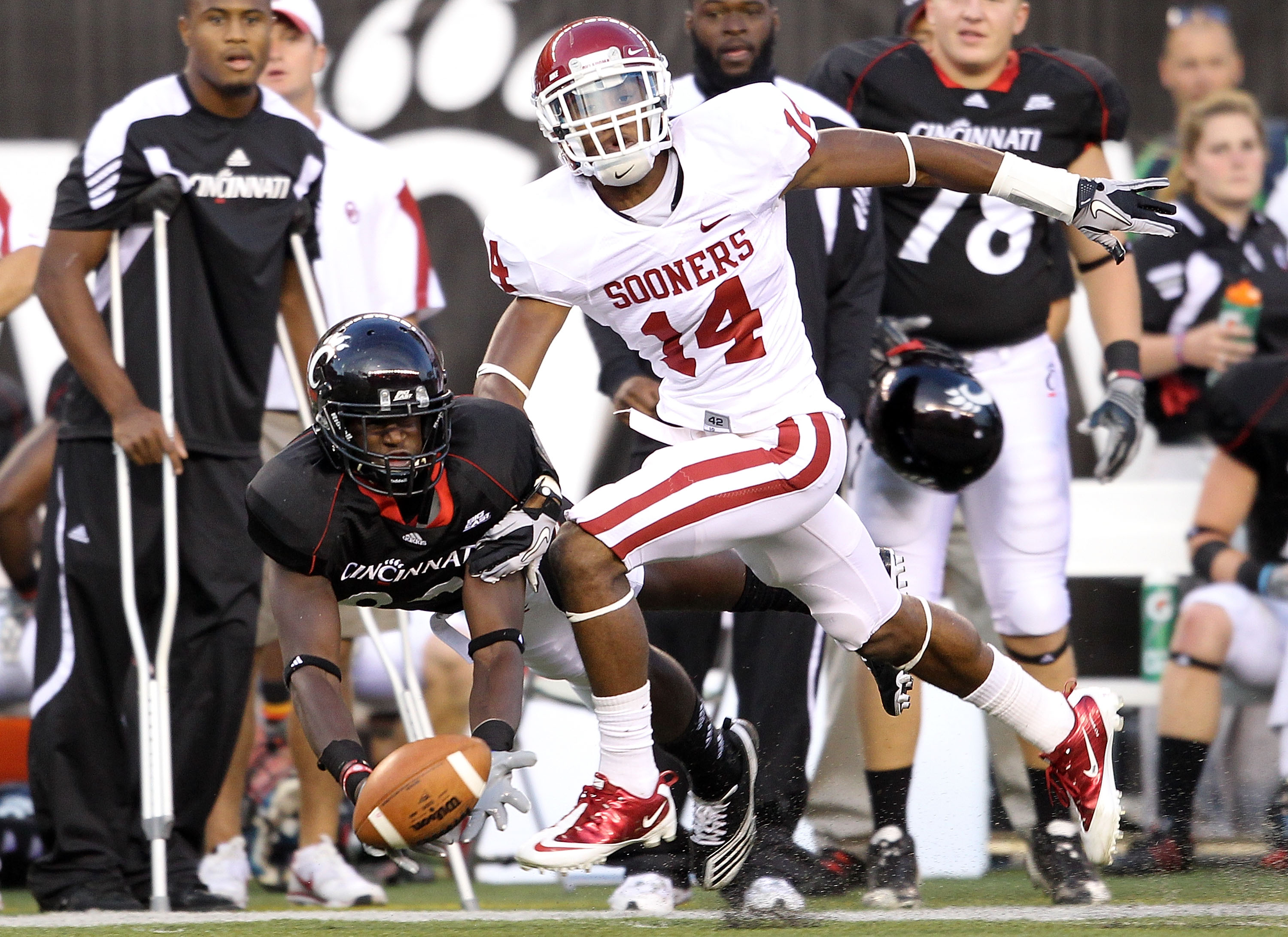CINCINNATI - SEPTEMBER 25:  Armon Binns #80 of the Cincinnati Bearcats reaches up for a pass while defended by Aaron Colvin #14 of the Oklahoma Sooners during the game at Paul Brown Stadium on September 25, 2010 in Cincinnati, Ohio. The pass fell incomple