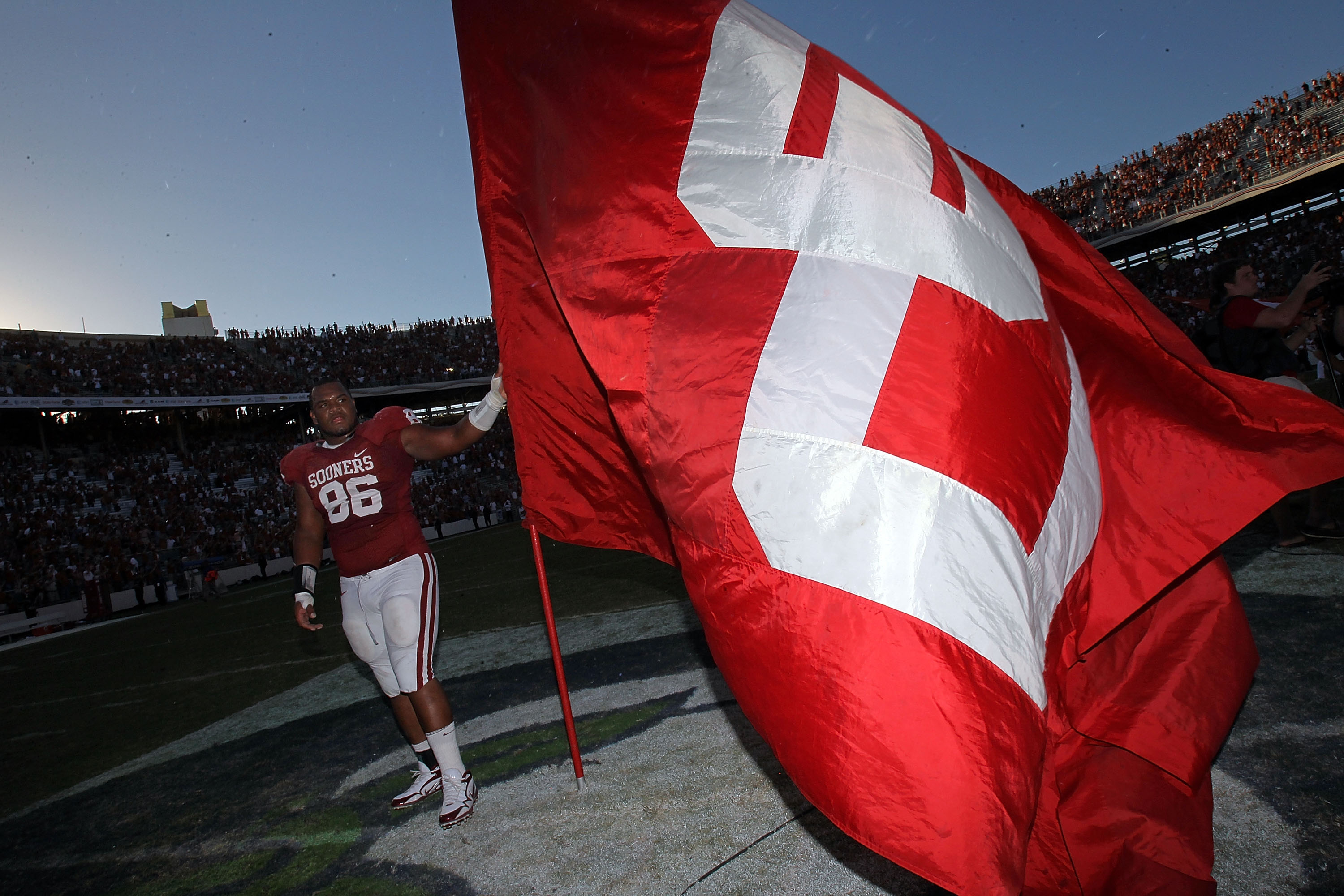 DALLAS - OCTOBER 02:  Defensive tackle Adrian Taylor #86 of the Oklahoma Sooners holds a flag while celebrating a28-20 win against the Texas Longhorns at the Cotton Bowl on October 2, 2010 in Dallas, Texas.  (Photo by Ronald Martinez/Getty Images)