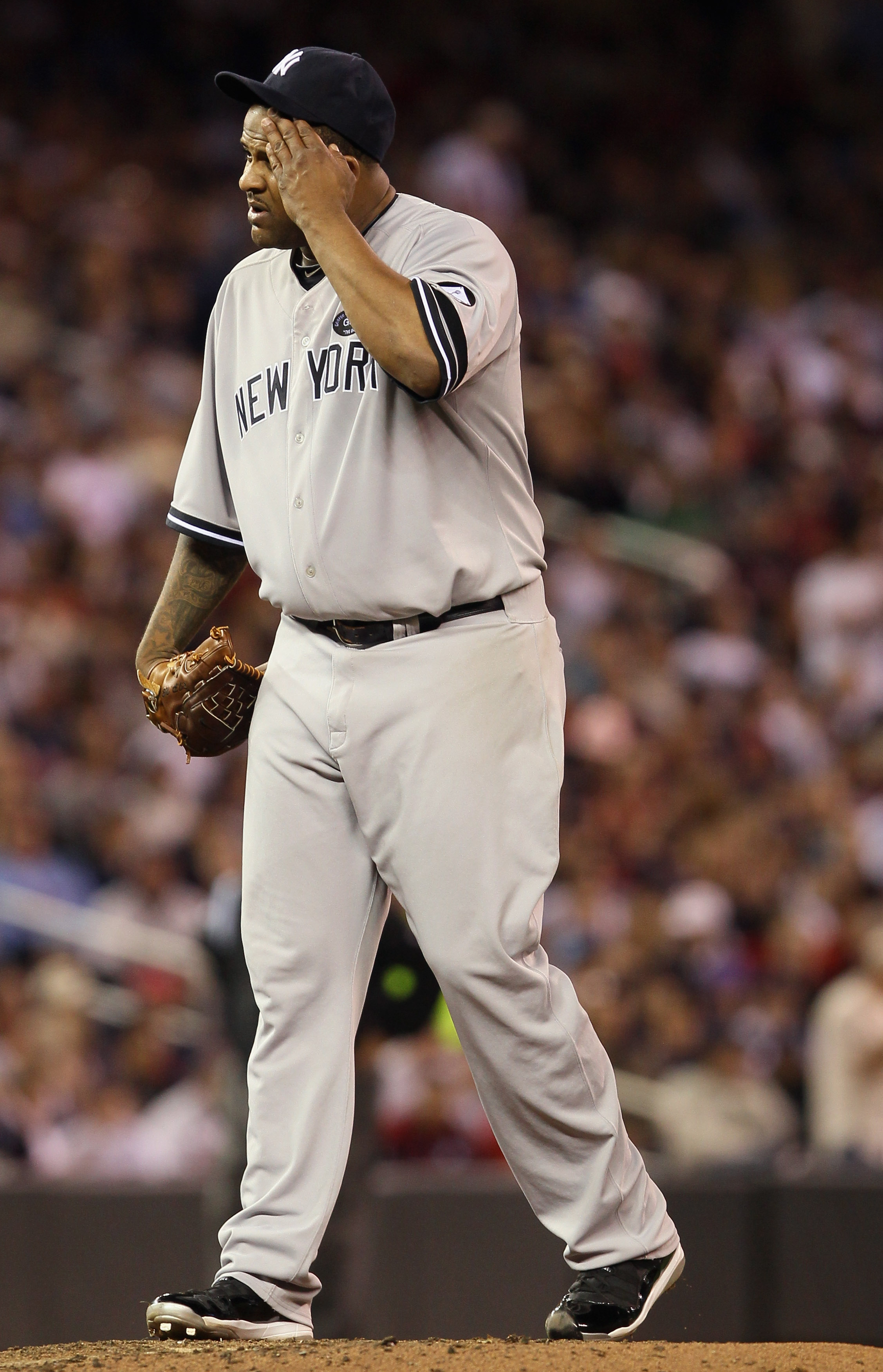 New York Yankees starting pitcher CC Sabathia wipes his face on